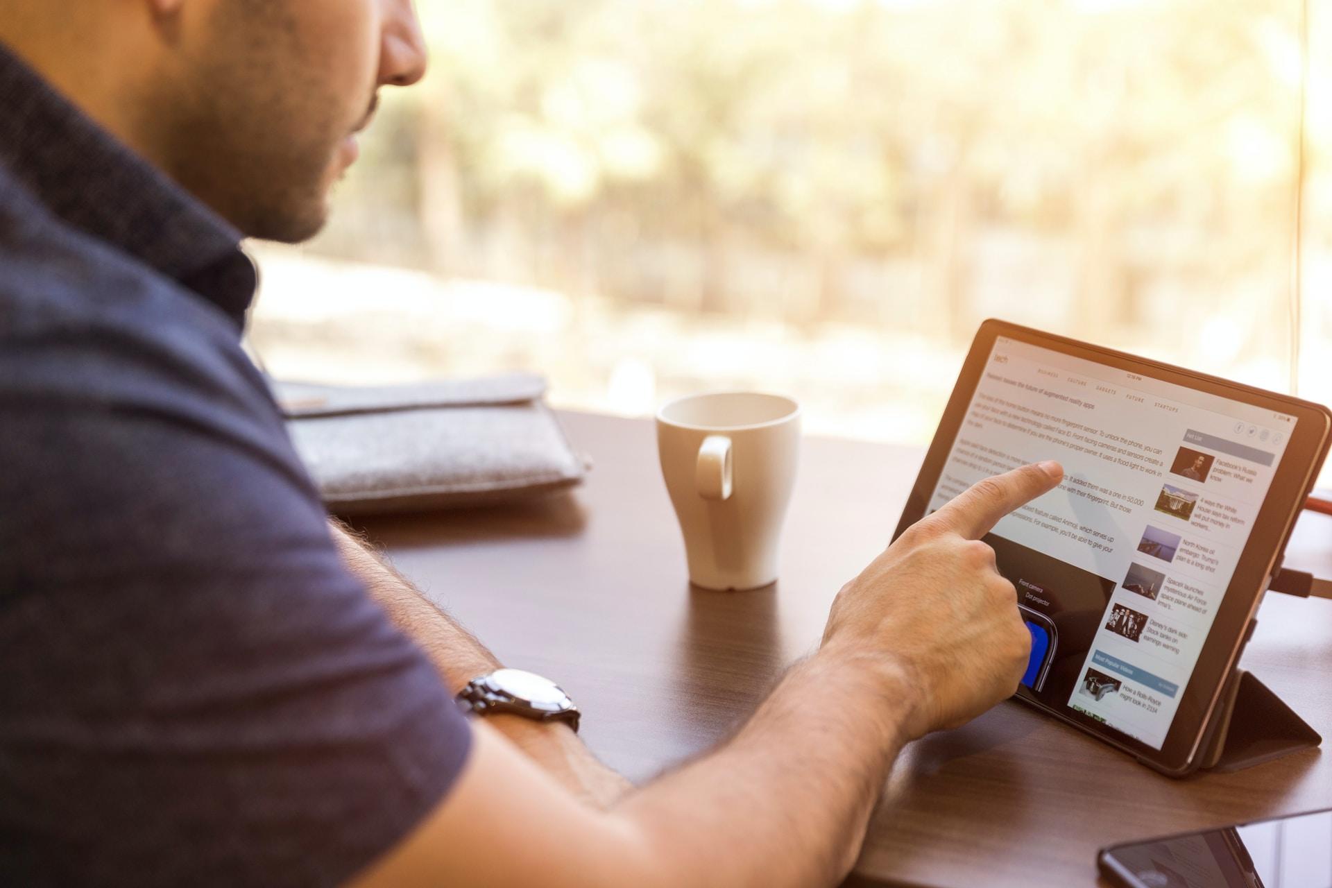 A man using a tablet to browse the internet.