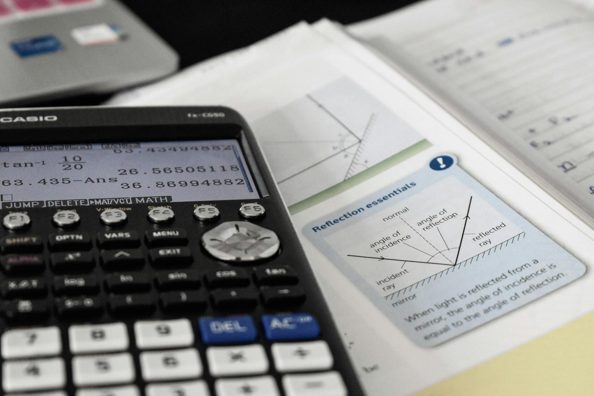 A calculator on a maths or physics textbook.