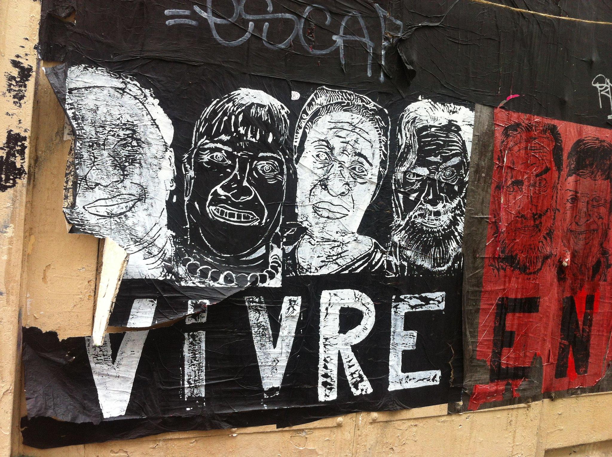 Street art that says "Vivre en" with several painted faces.