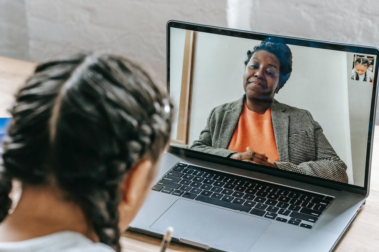 A young student learns with a virtual tutor on a laptop.