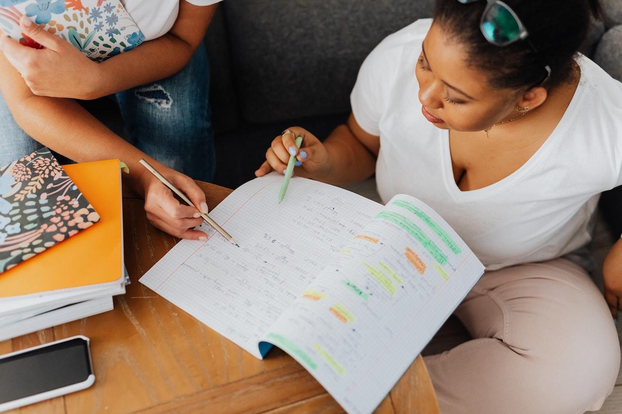 A student and a tutor work together in a notebook