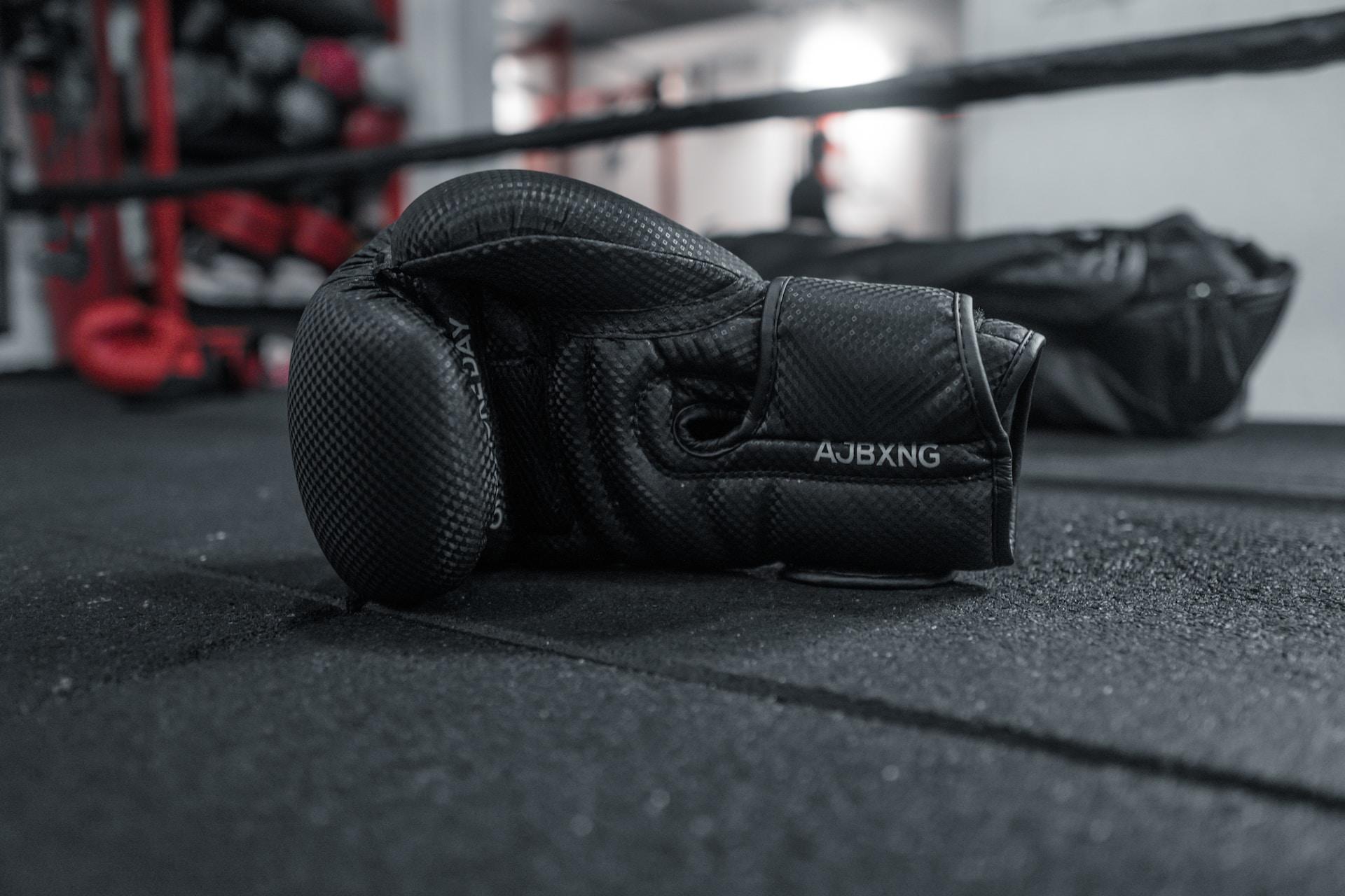 A pair of boxing gloves on the floor of a boxing ring.