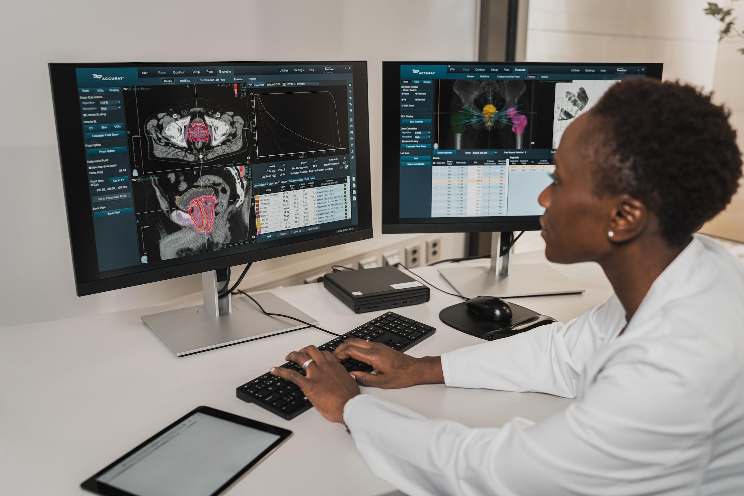 A doctor reads some scans on a computer screen
