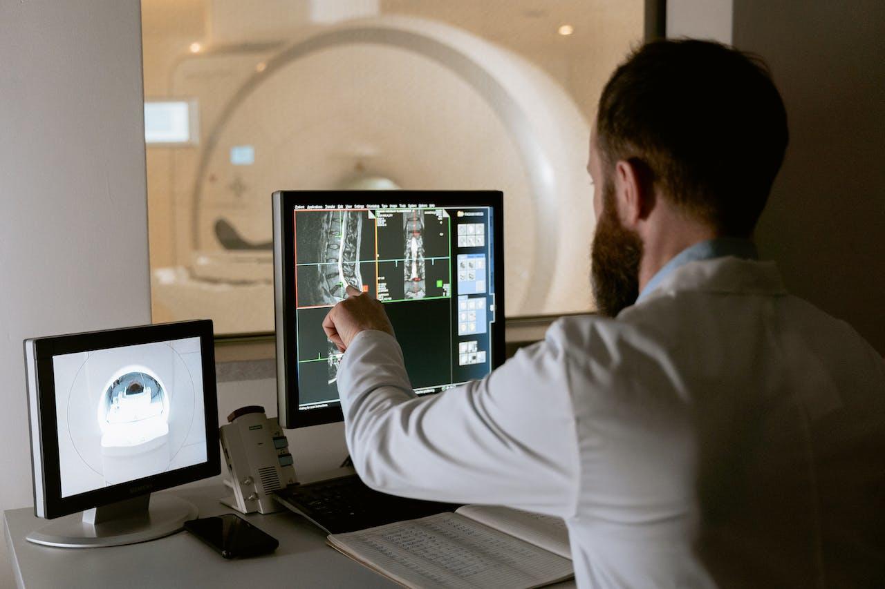 A doctor reads a medical scan on a computer