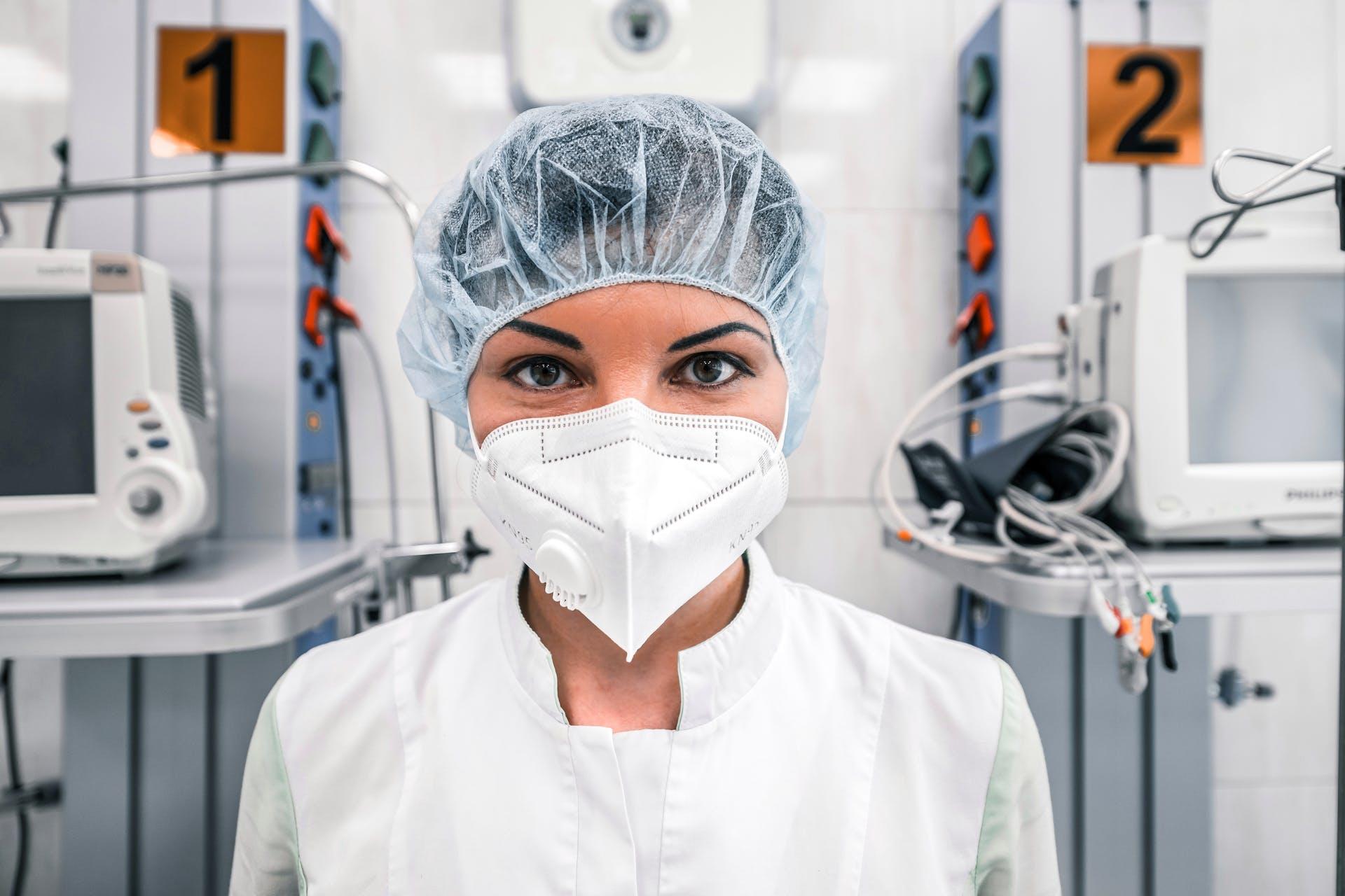 Close up of a doctor smiling behind their medical mask in the operating theatre