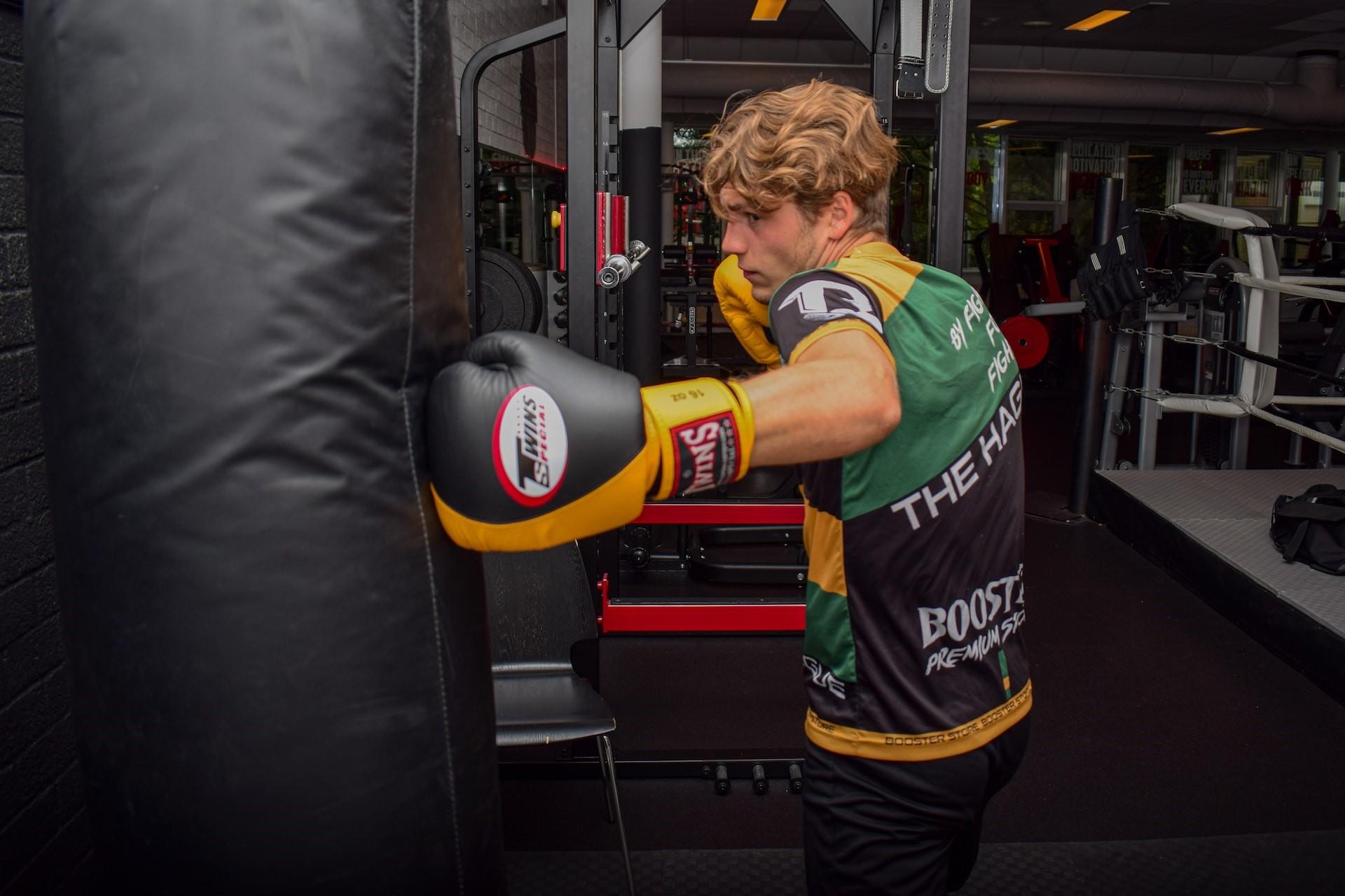 A man boxing against a punching bag.