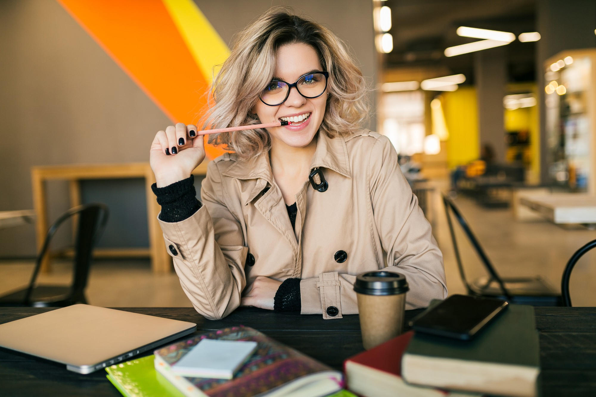 A student has an idea while sitting at a table with her coffee and books