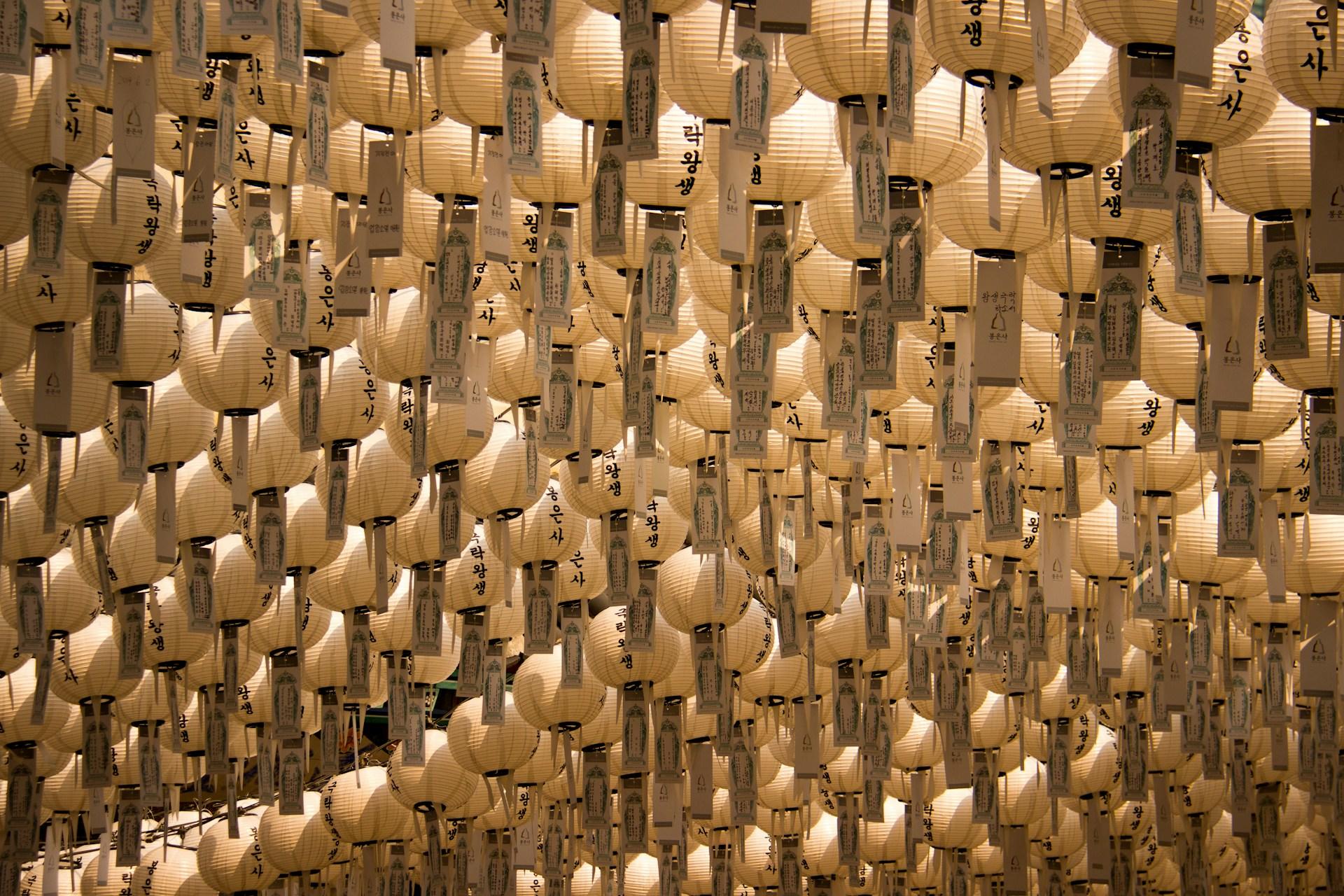 Many paper lanterns with Korean writing on them.