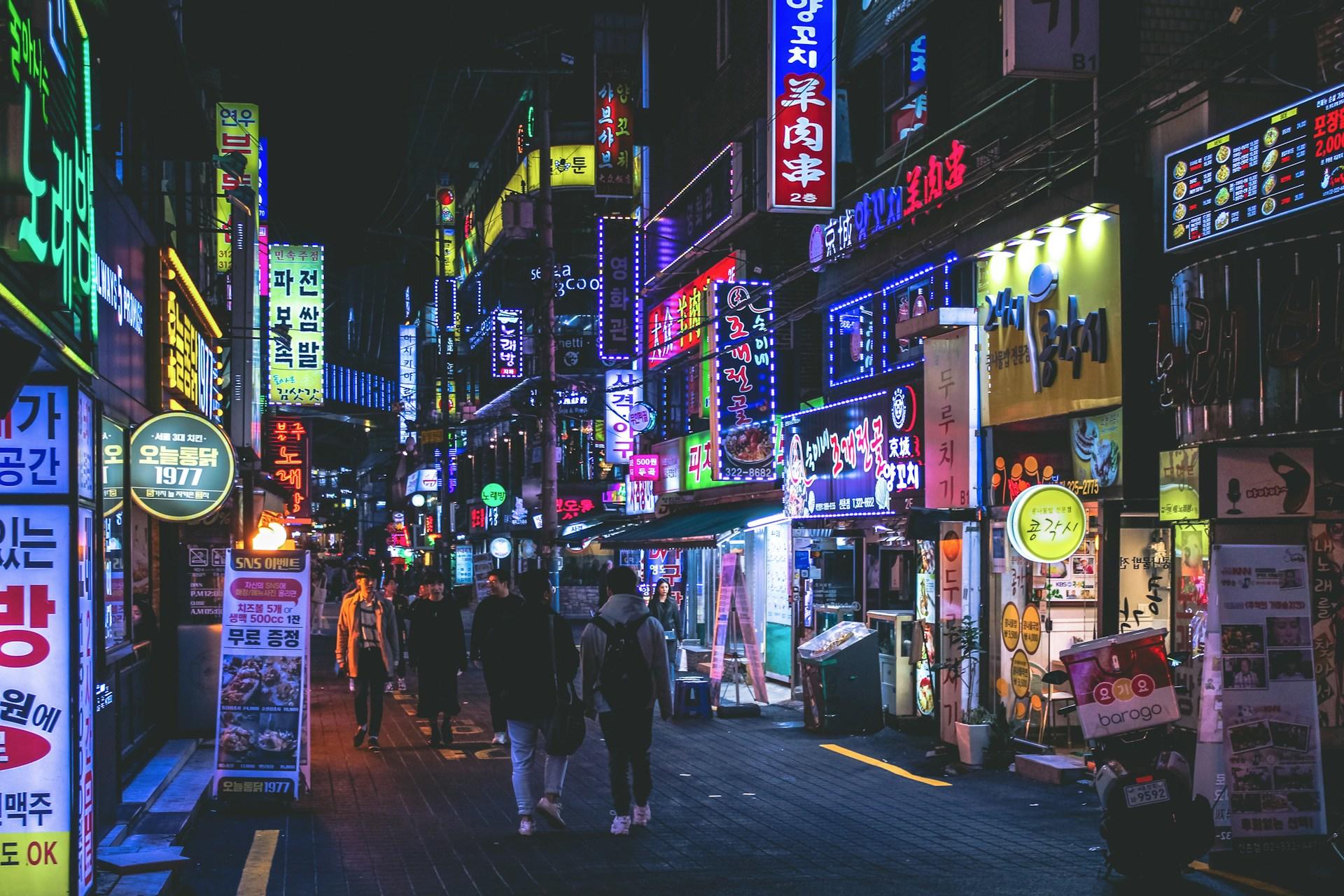 A street in Seoul, South Korea, illuminated by many neon signs.