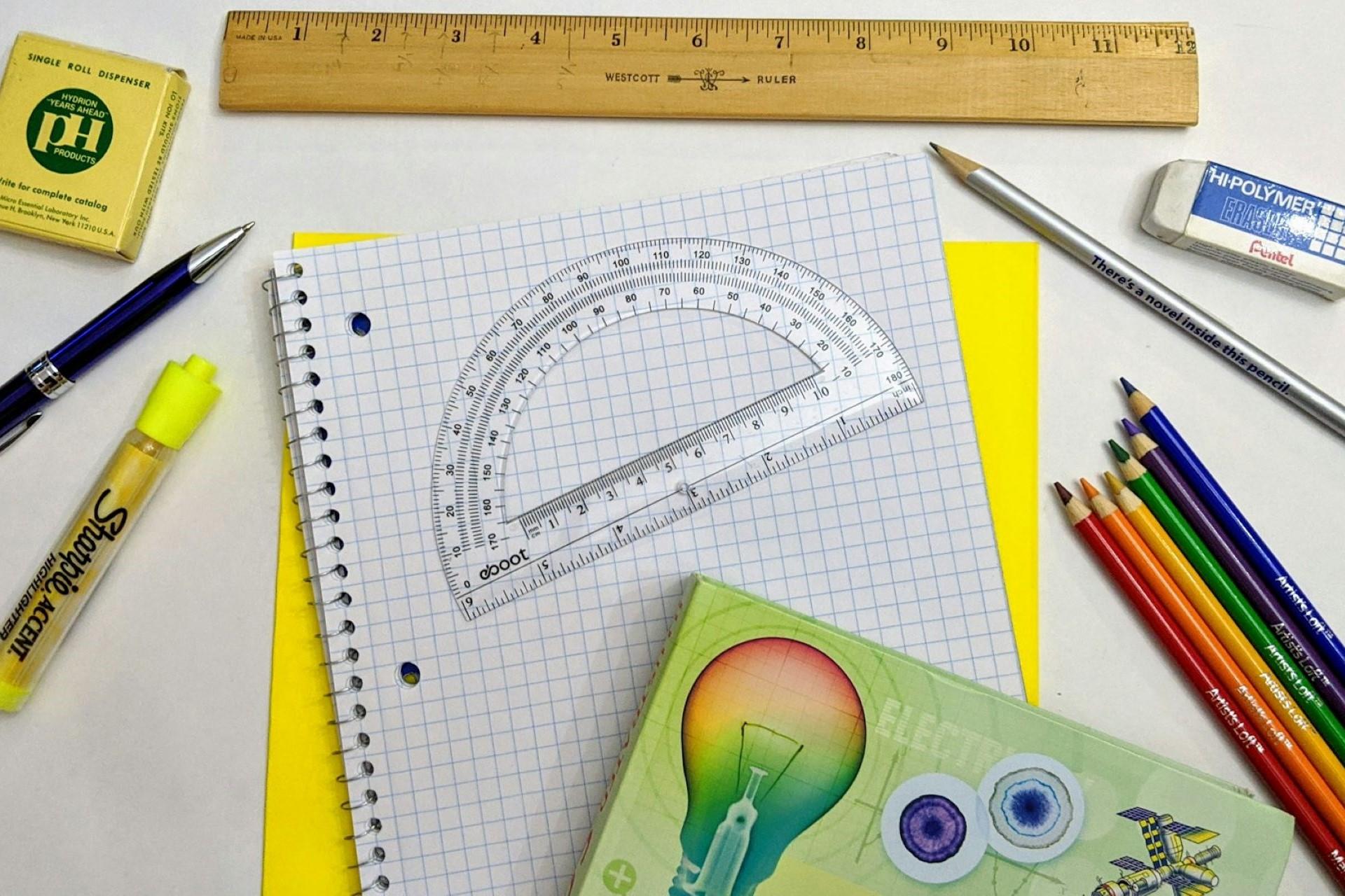Different kinds of school supplies on a desk.