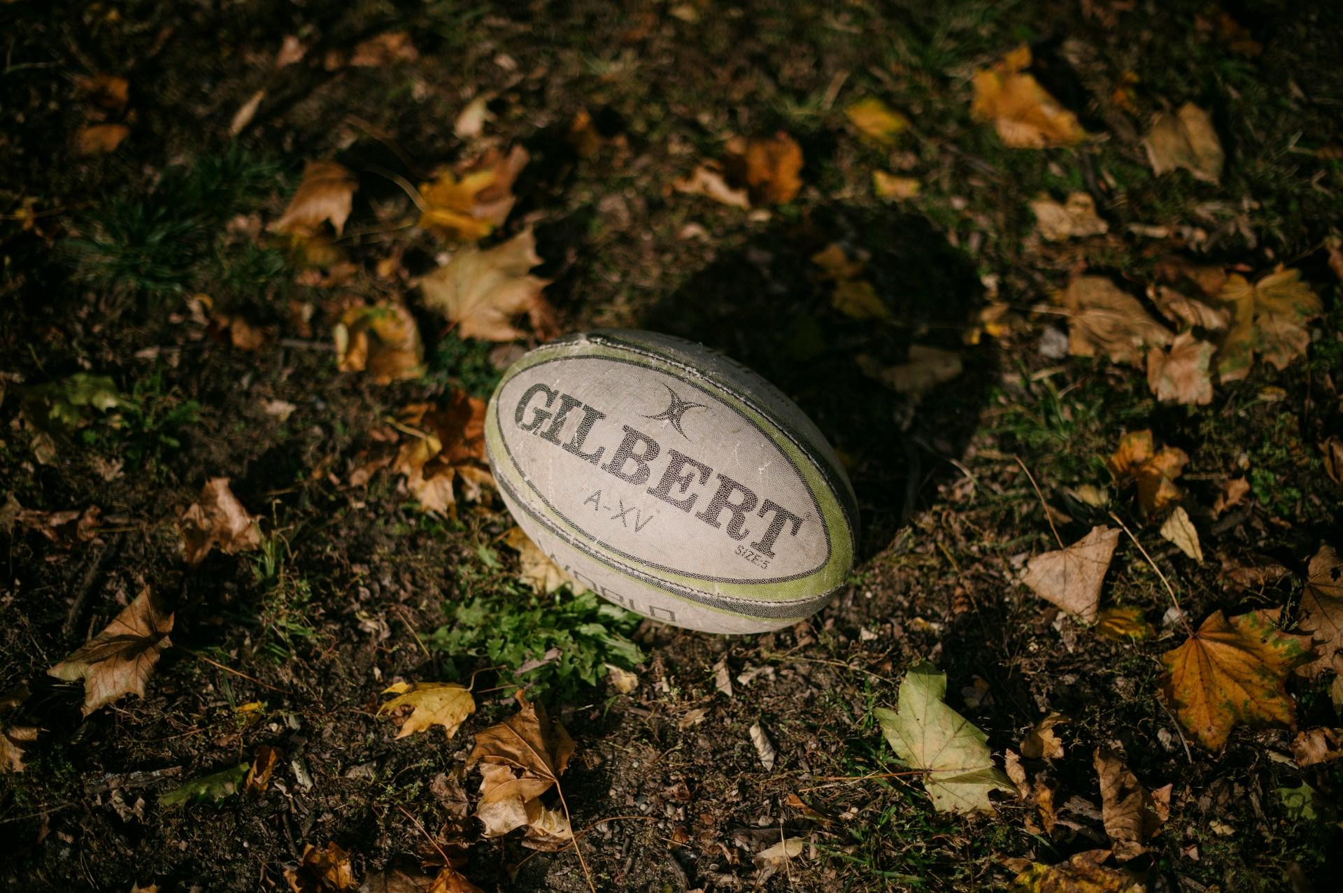A Gilbert Rugby ball in the mud.