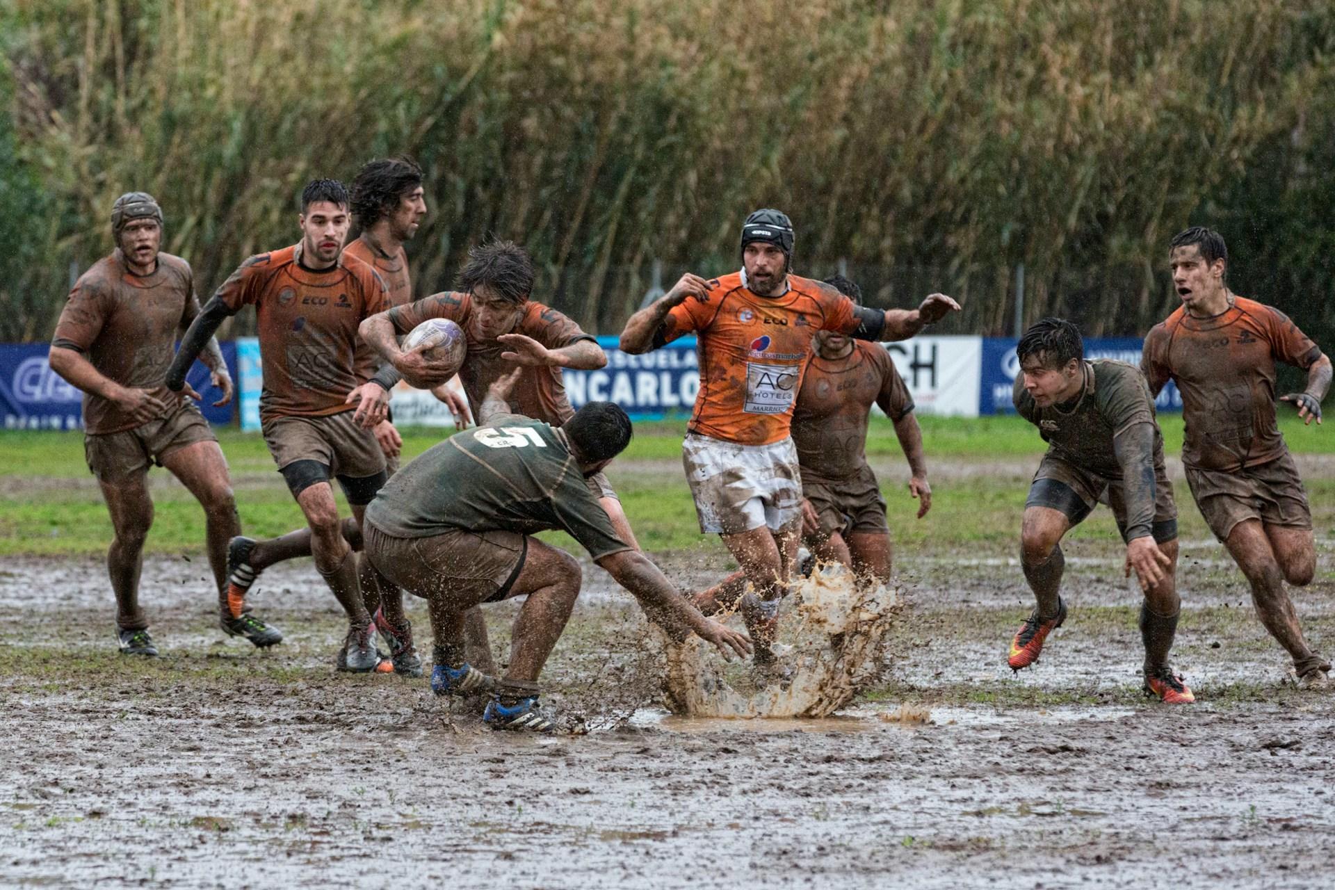 Rugby players playing in the rain.