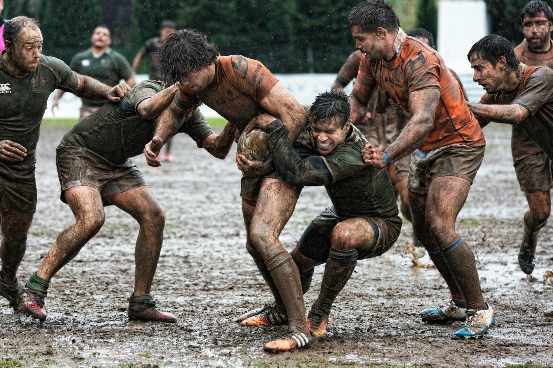Several very muddy rugby players.