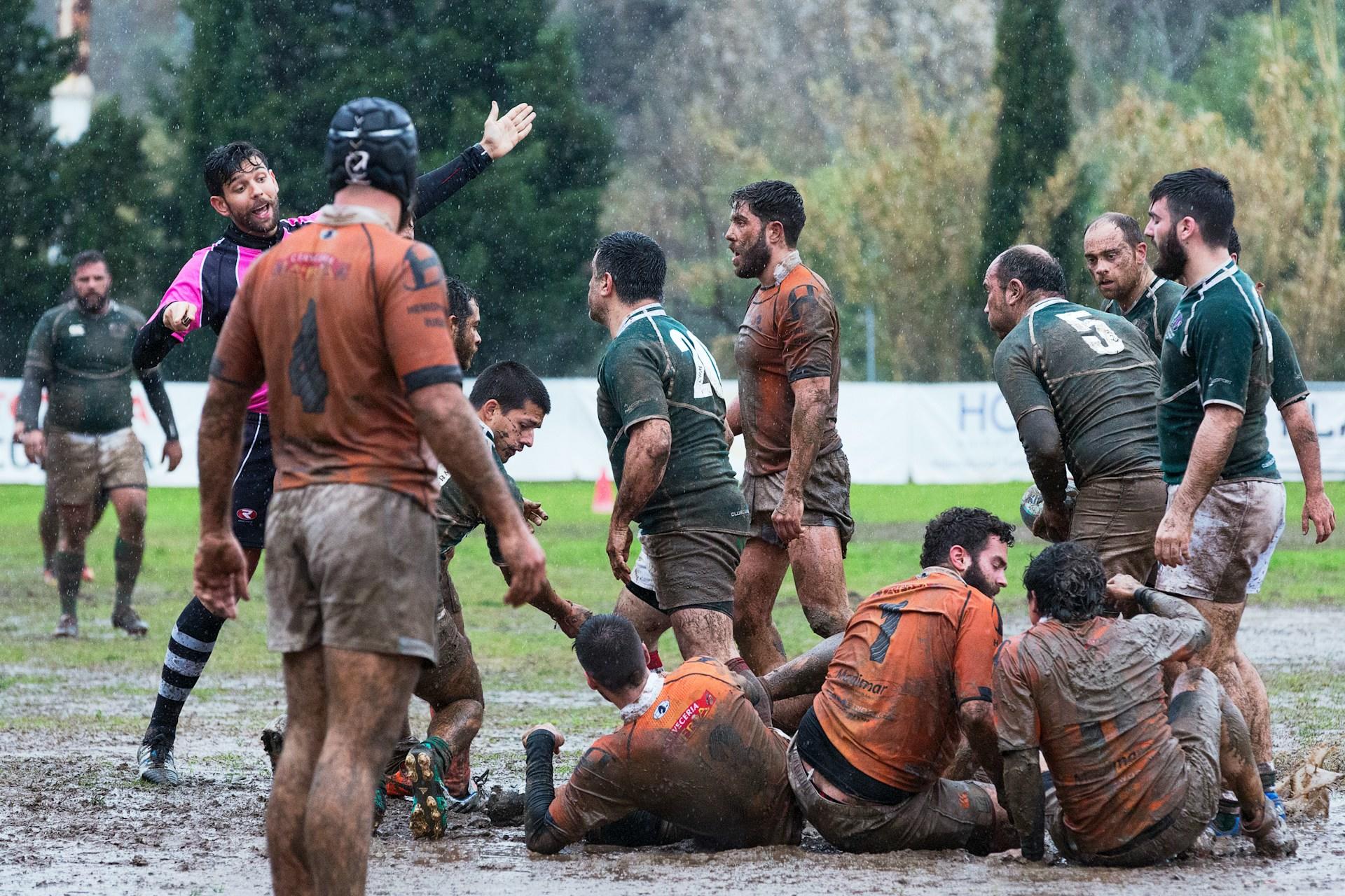 Several rugby players in a lot of mud.