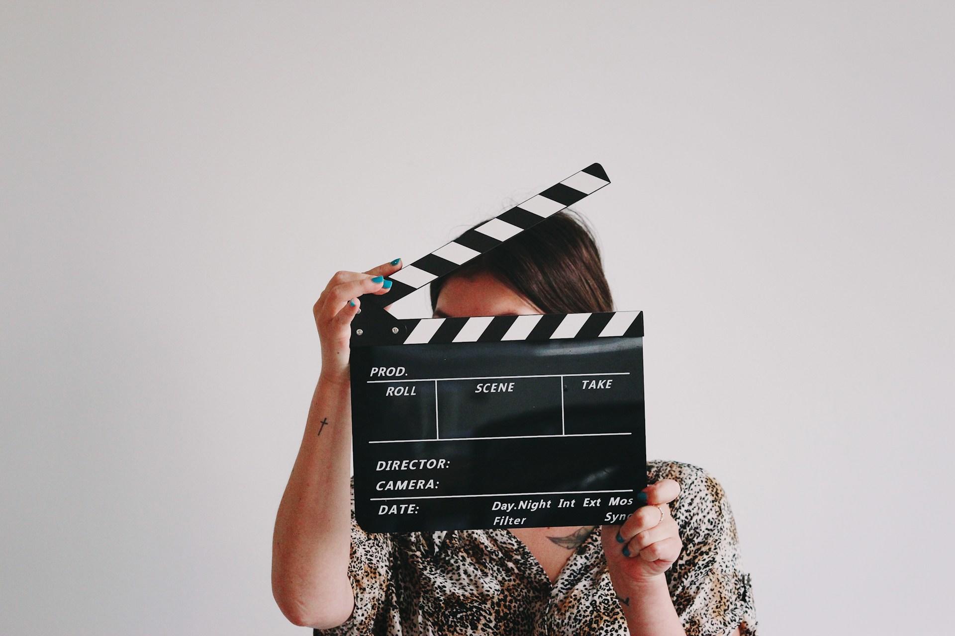 A woman holding up a clapper board.