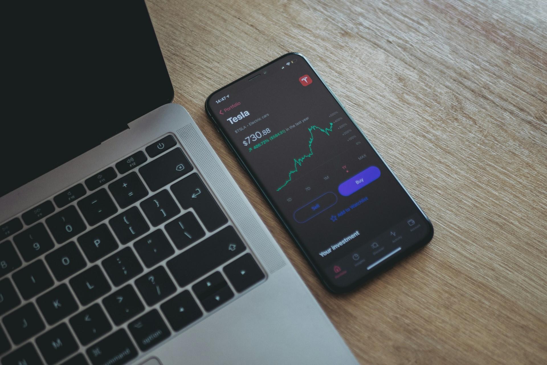 A smartphone with Tesla stocks on the screen.