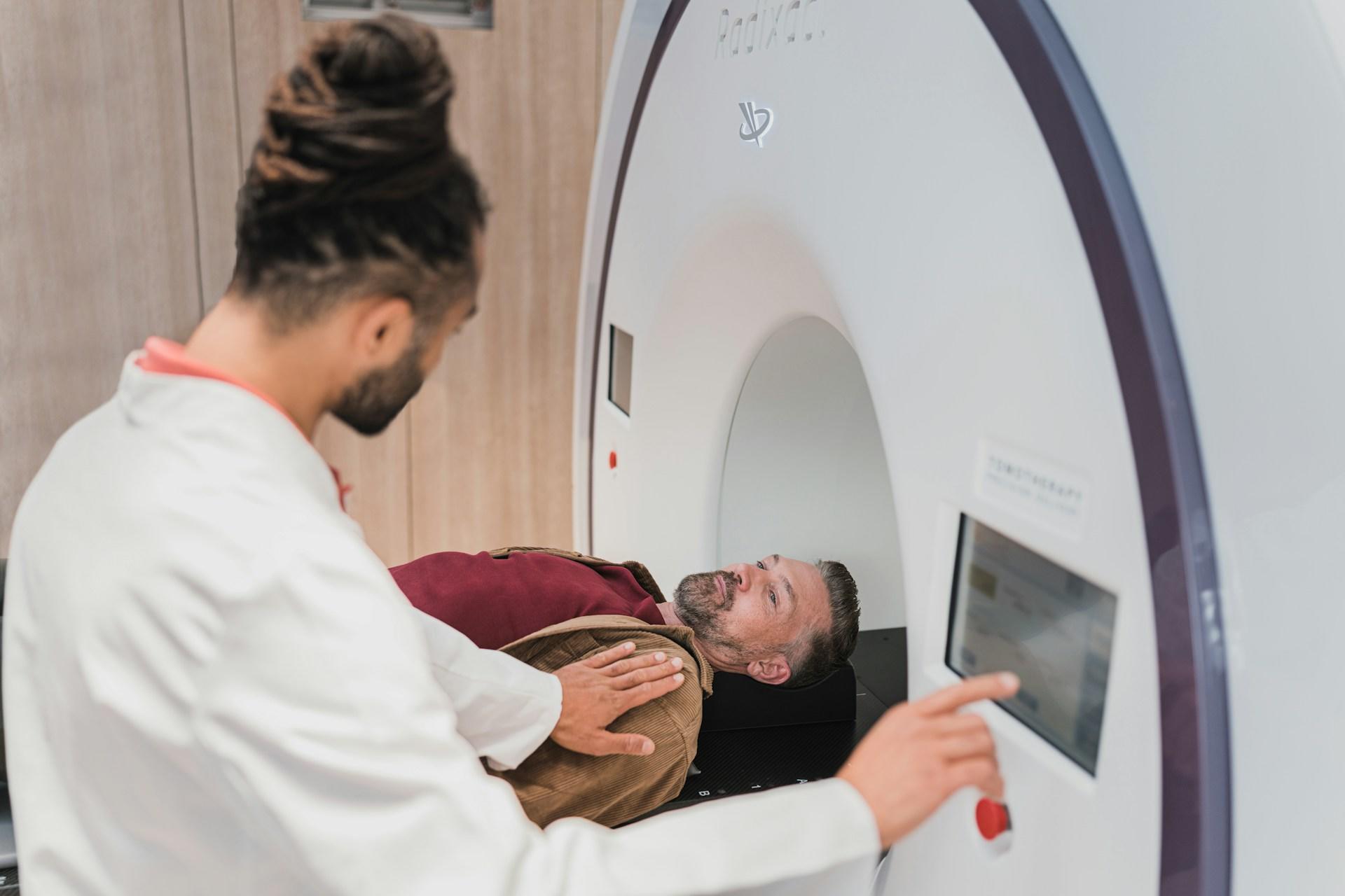 A doctor with a patient going into an MRI machine.