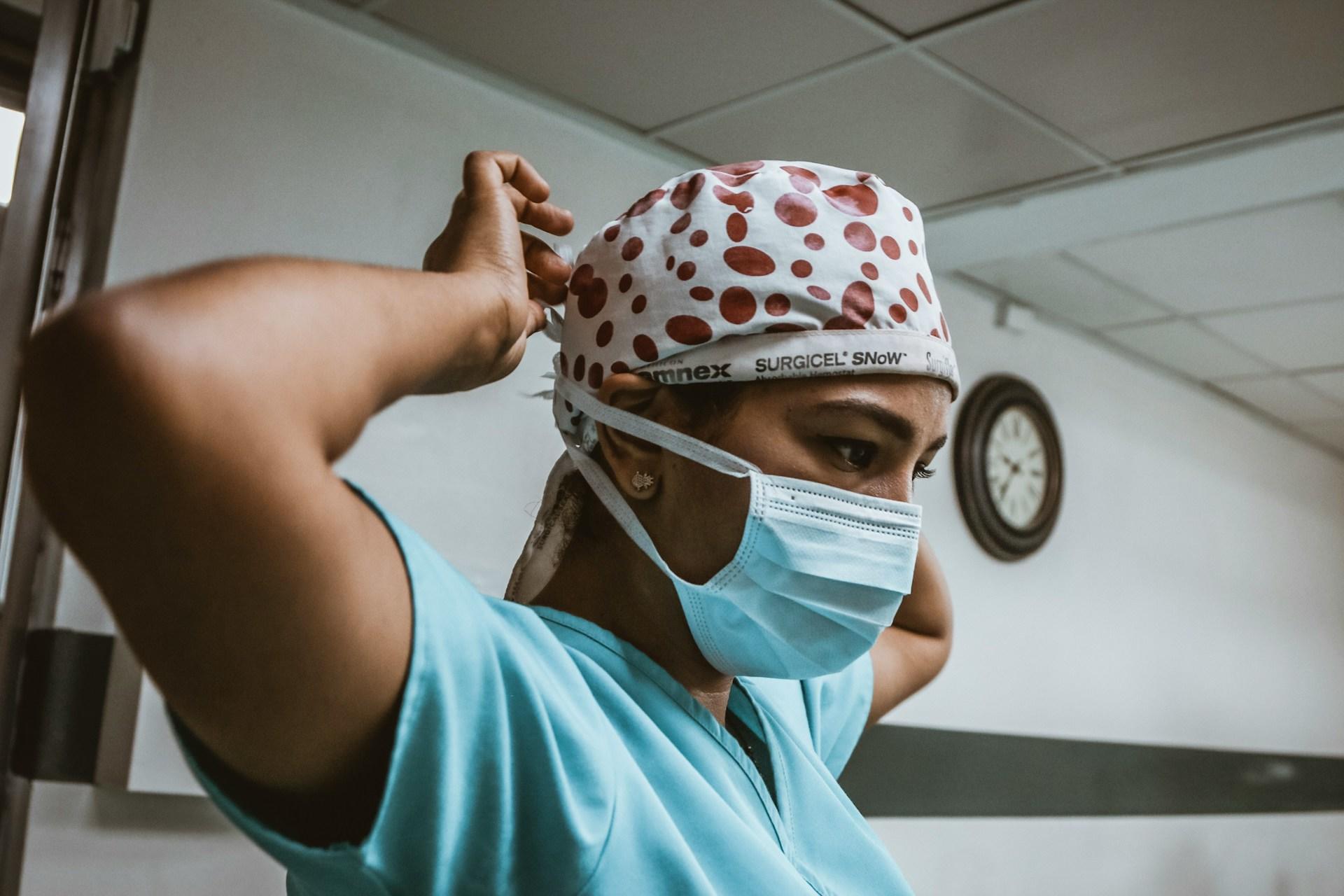 A doctor in scrubs and a mask.