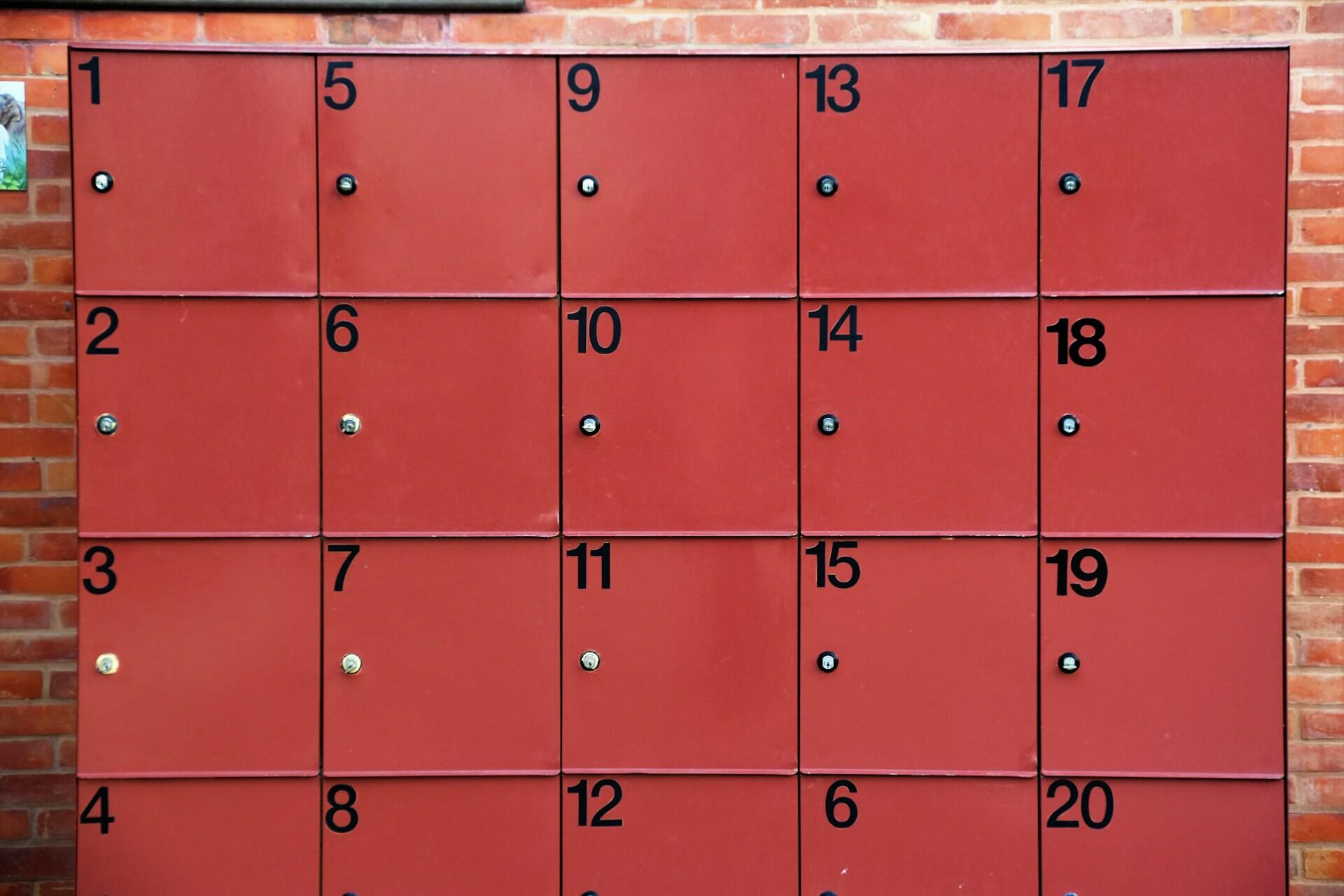 Red lockers arranged in rows, each marked with a black number.