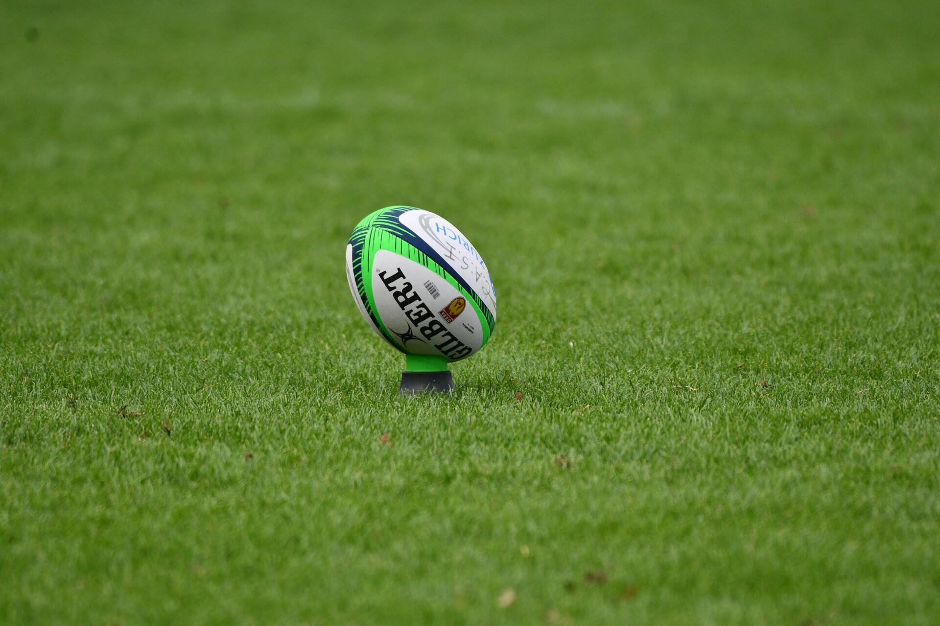 Rugby ball placed on a kicking tee on a grass field
