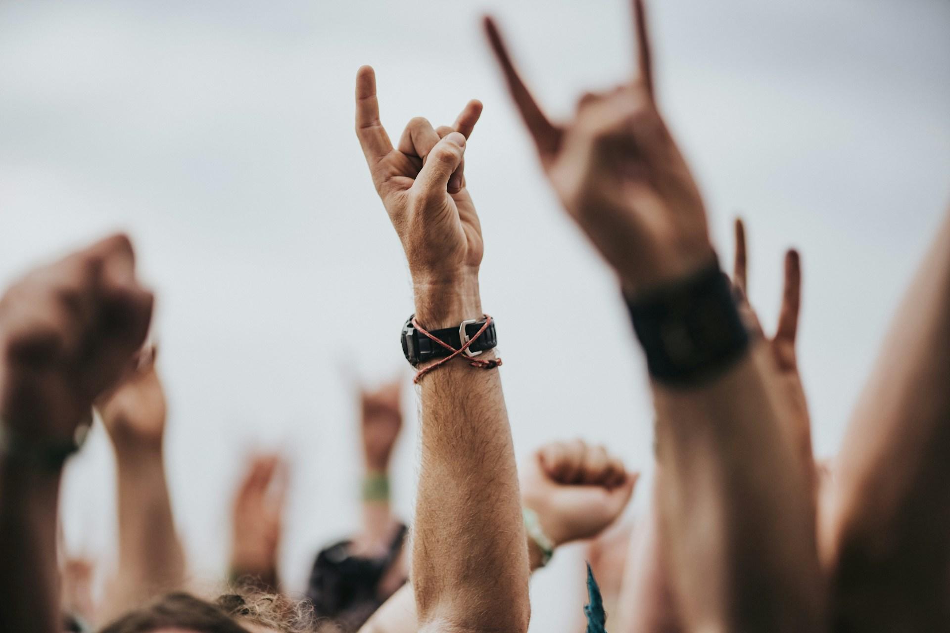 Concertgoers making the "rock" hand gesture.