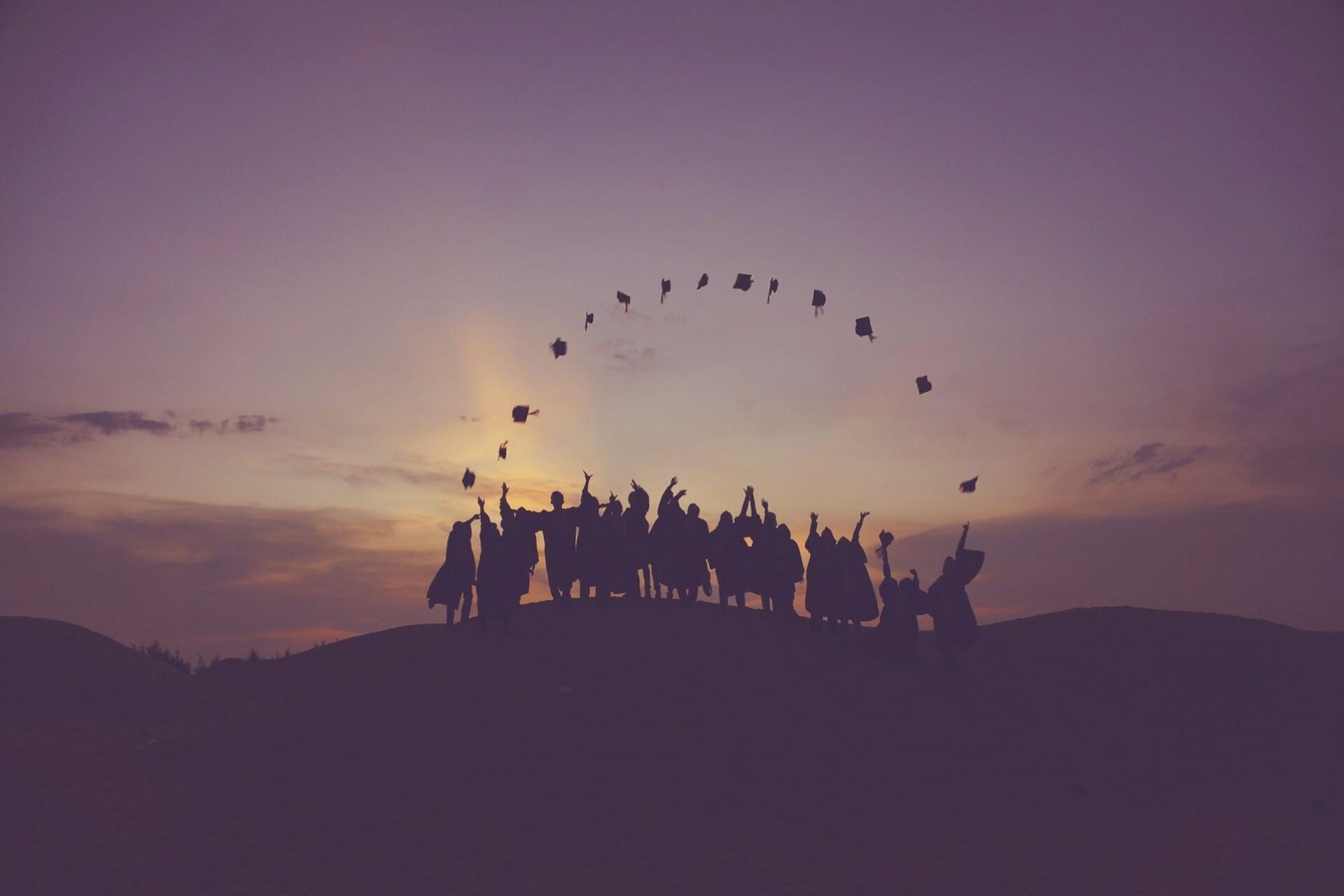 Graduates throwing their graduation caps in the air.