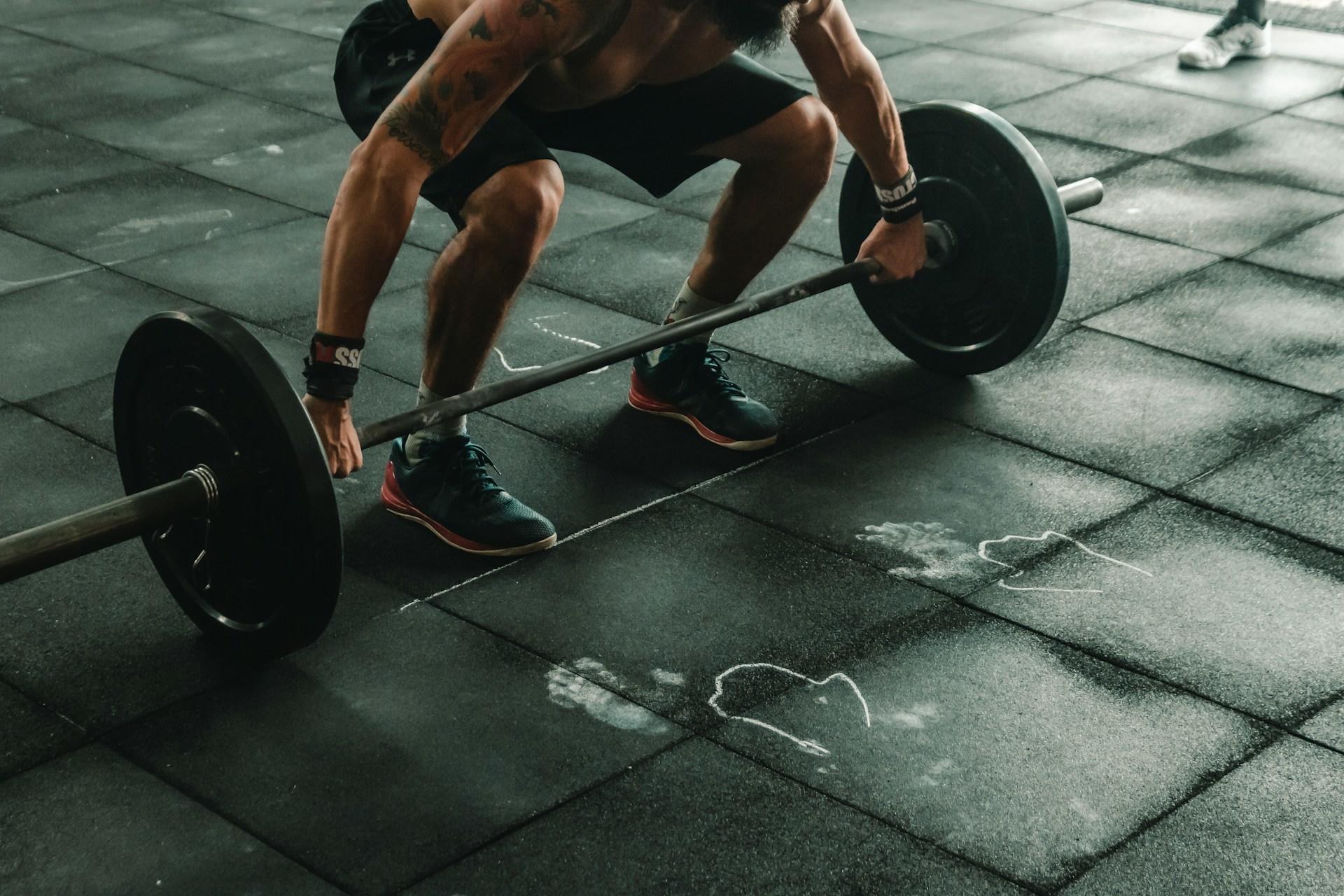 A woman lifting a barbell in a gym.