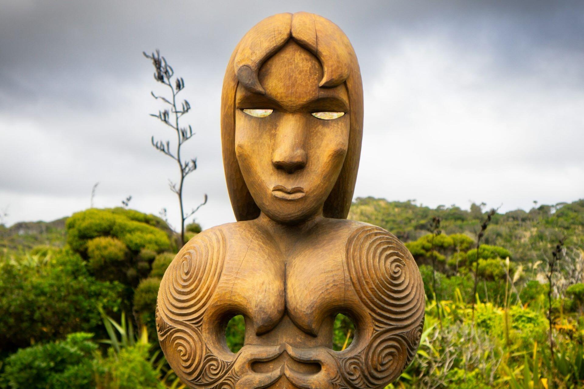 Contemporary wooden Māori carving in a New Zealand landscape