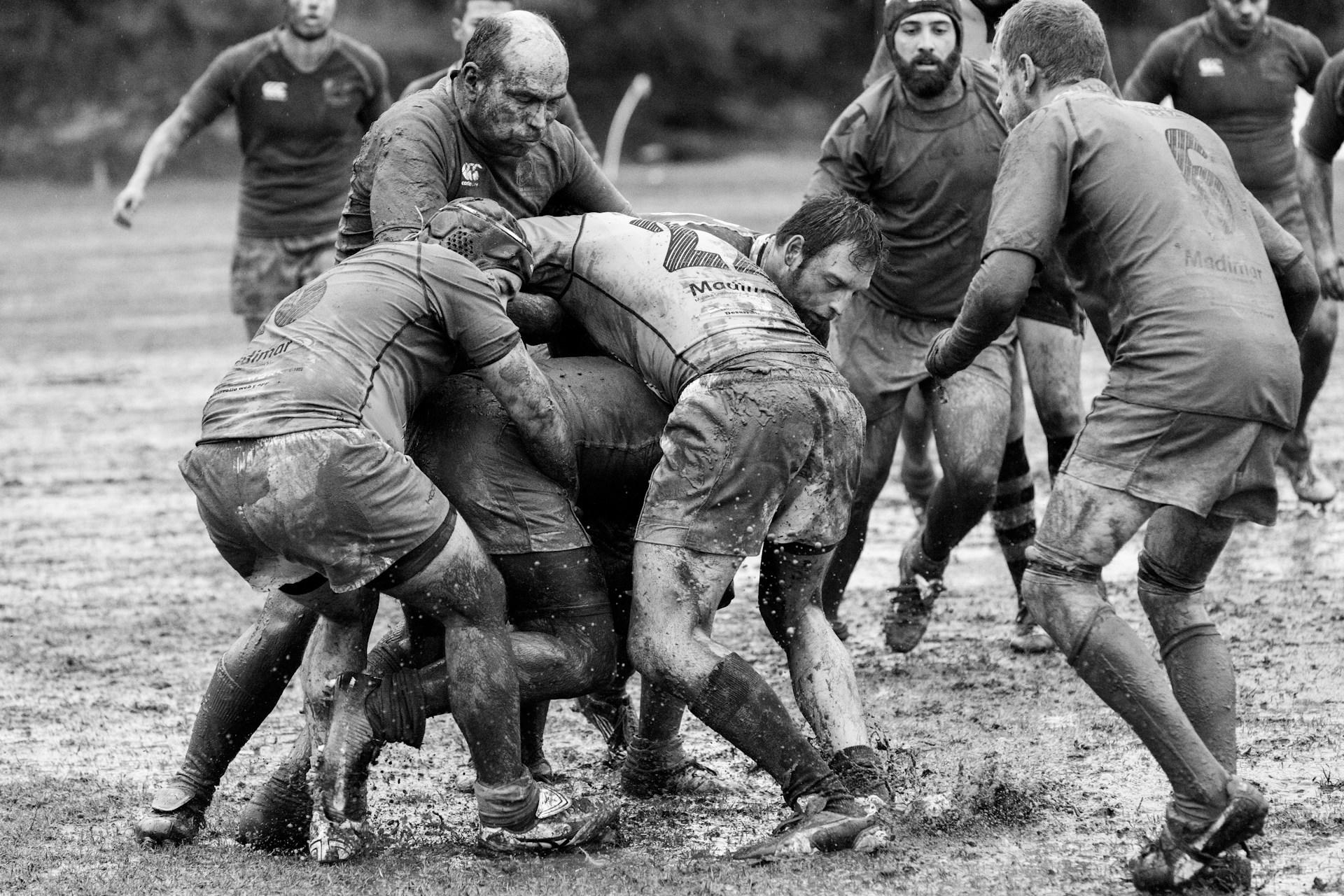 Rugby players in the middle of a muddy match.