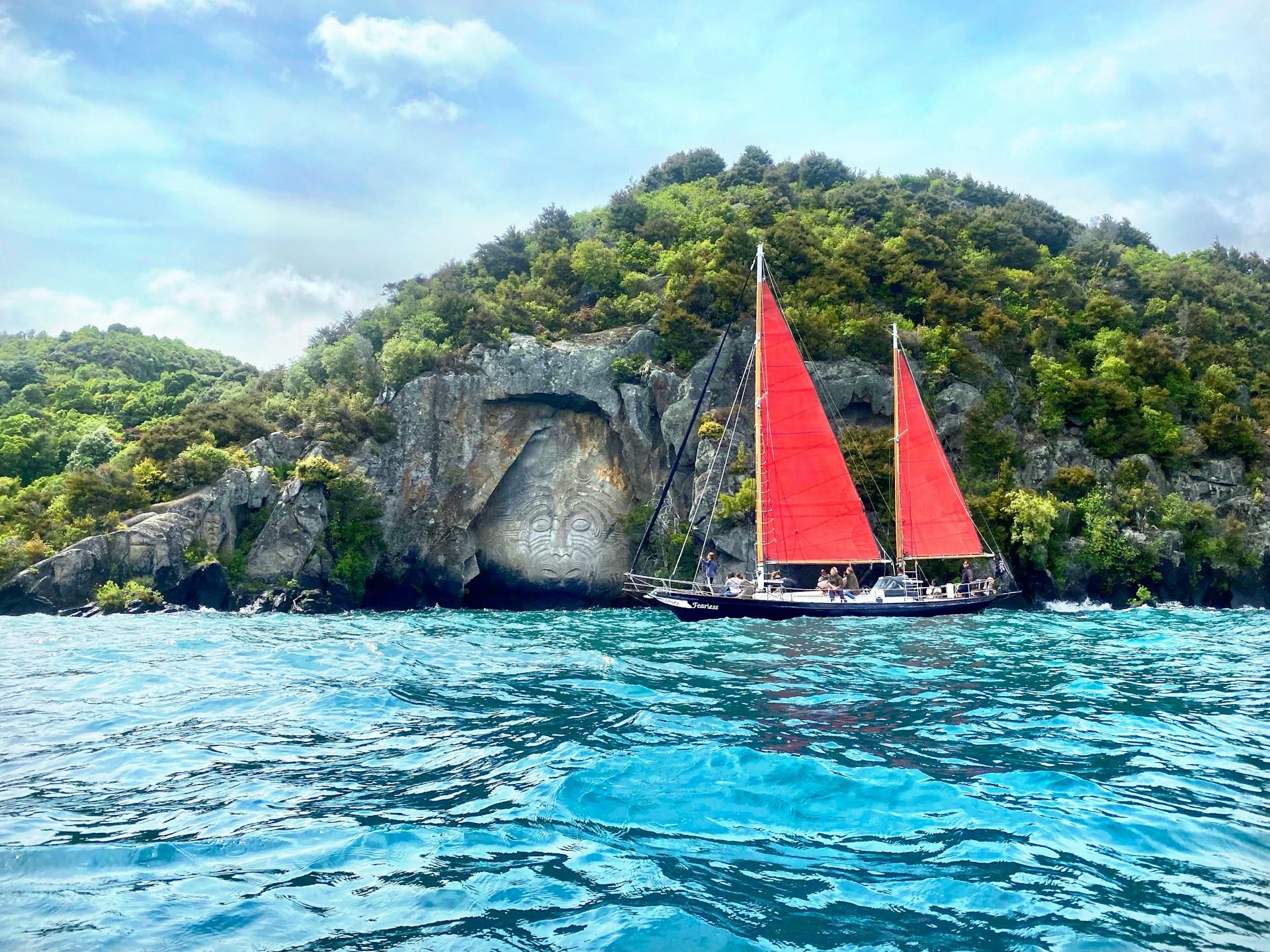 A boat passing in front of a Maori carving.