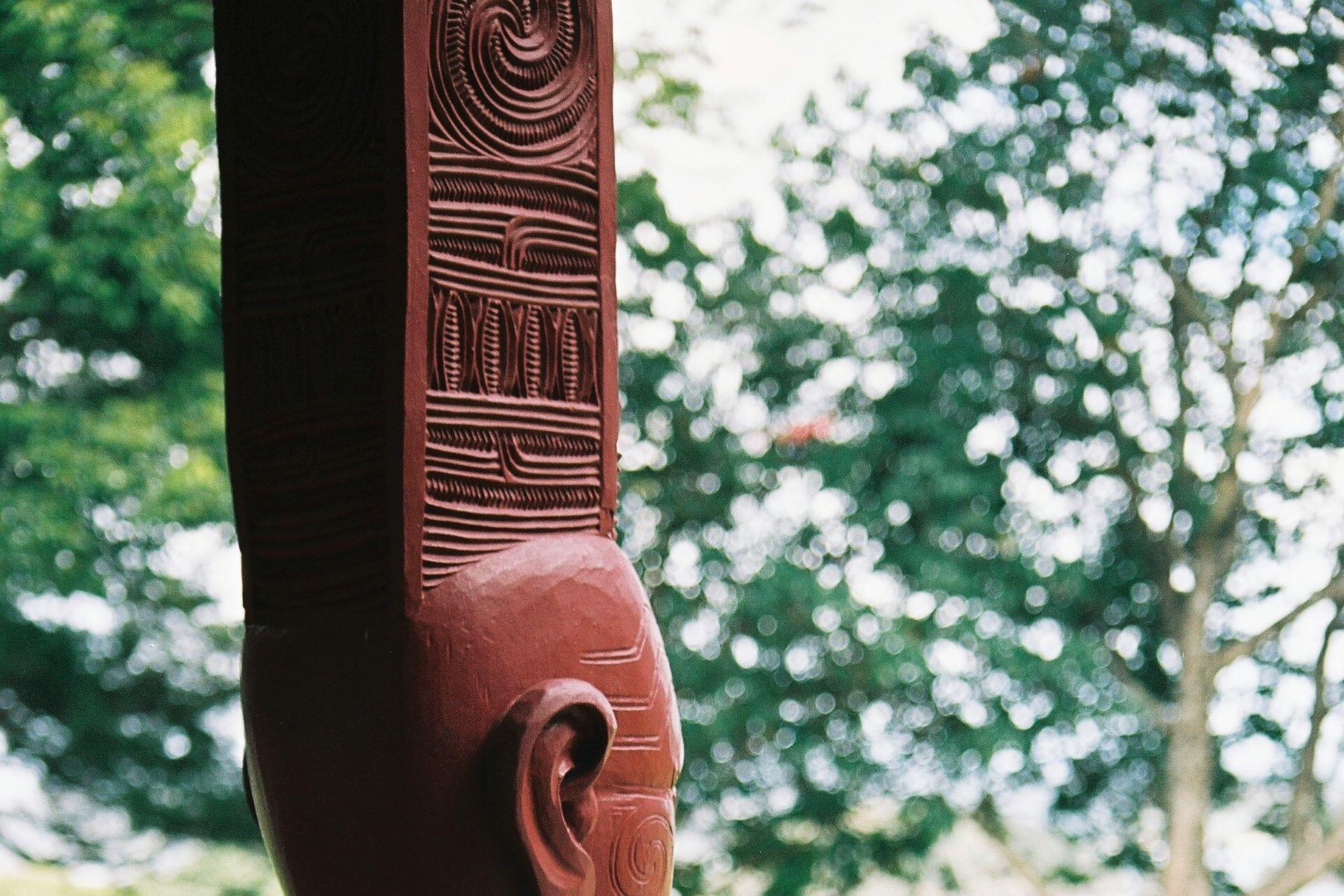 Māori carved figure with traditional carved patterns