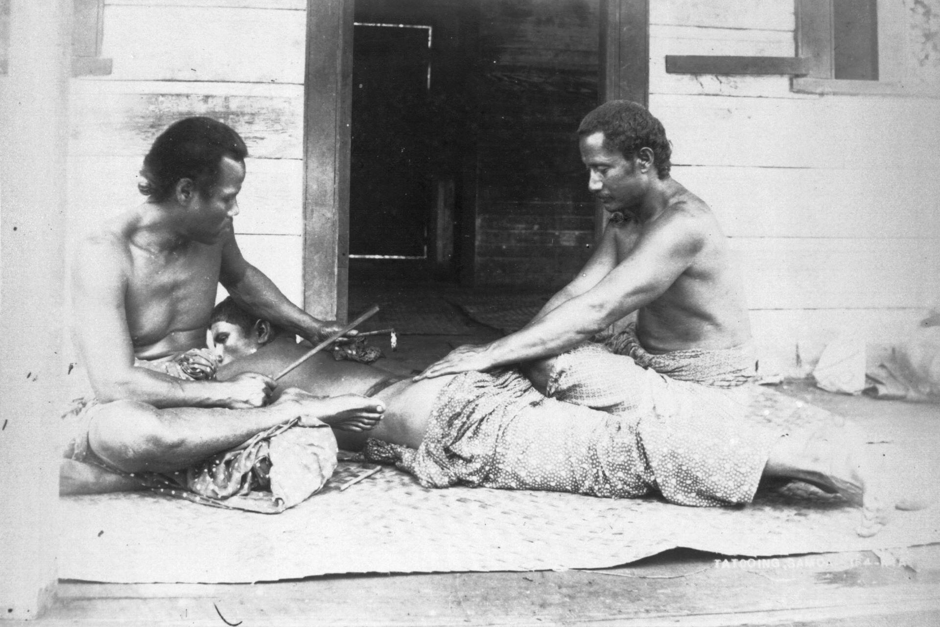 Historical photograph showing traditional Sāmoan tatau being applied