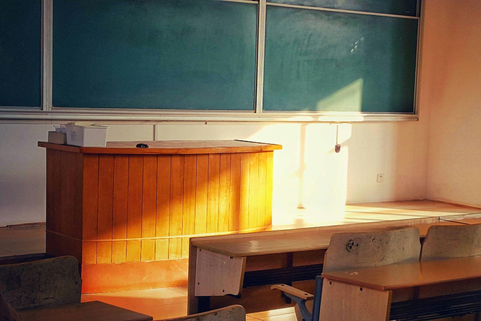 Empty classroom with desks and a blackboard