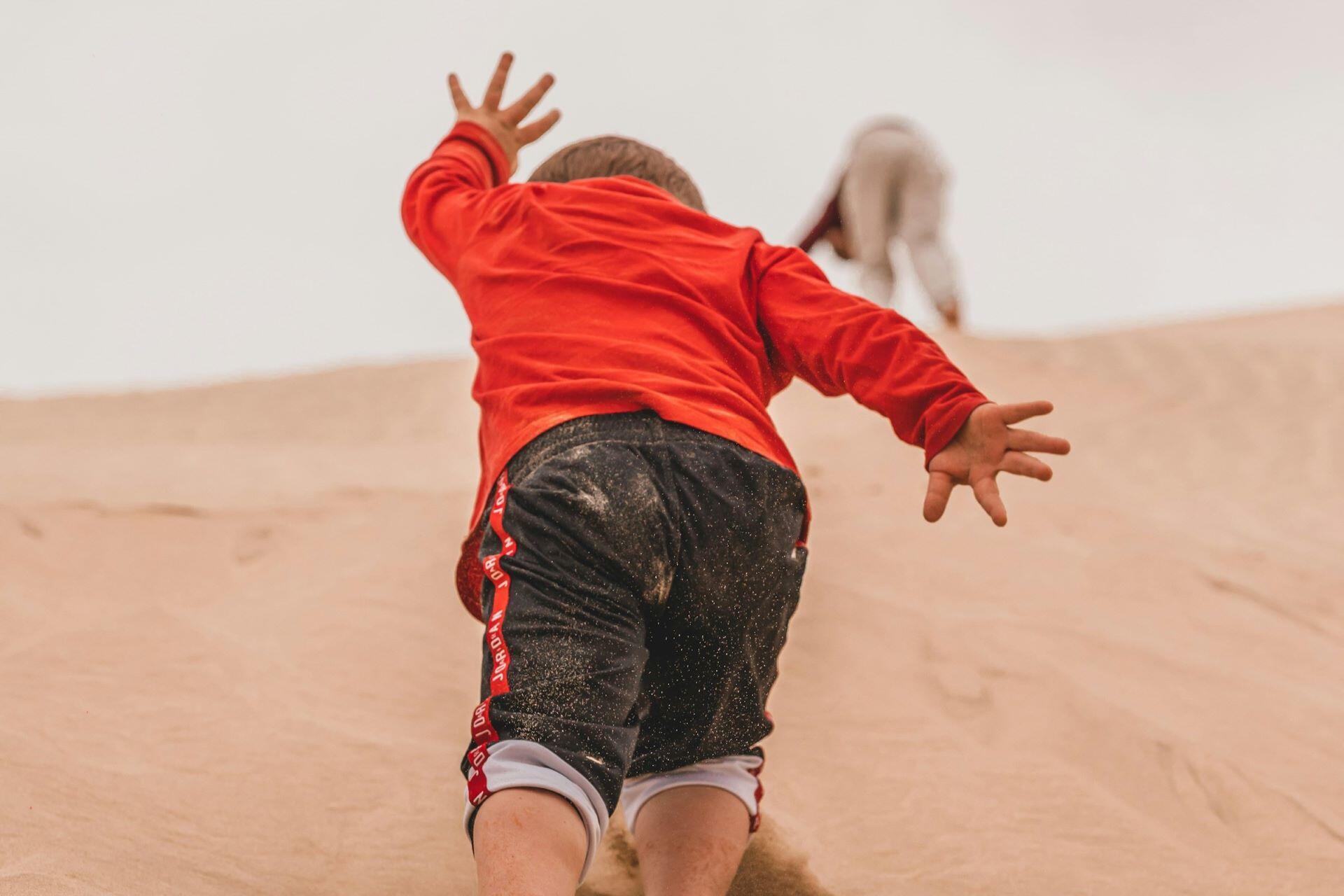 Child running across sand during the school holidays
