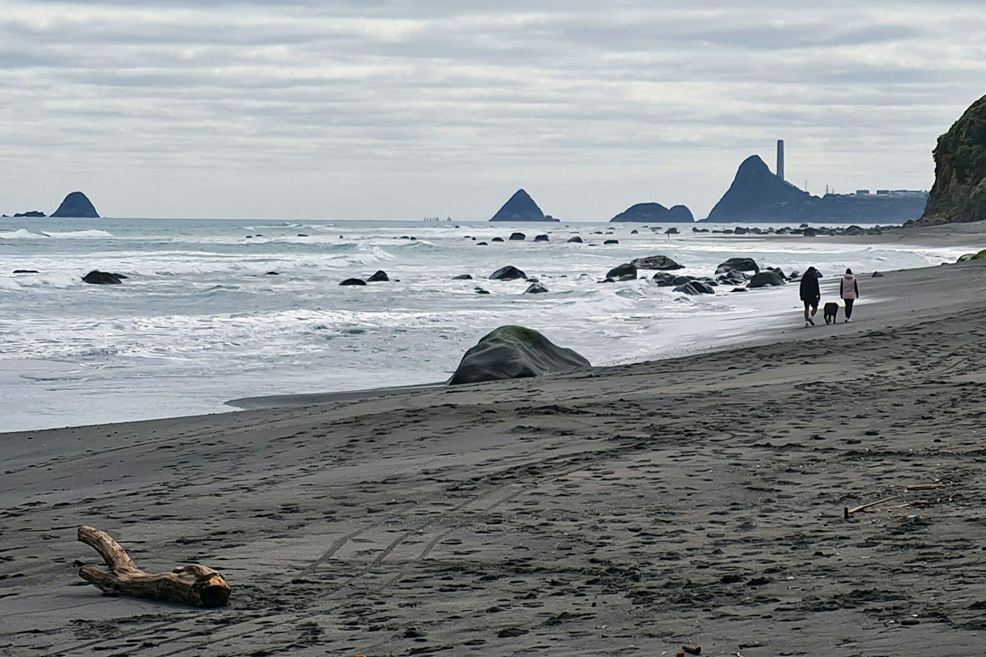 People walking along a New Zealand beach