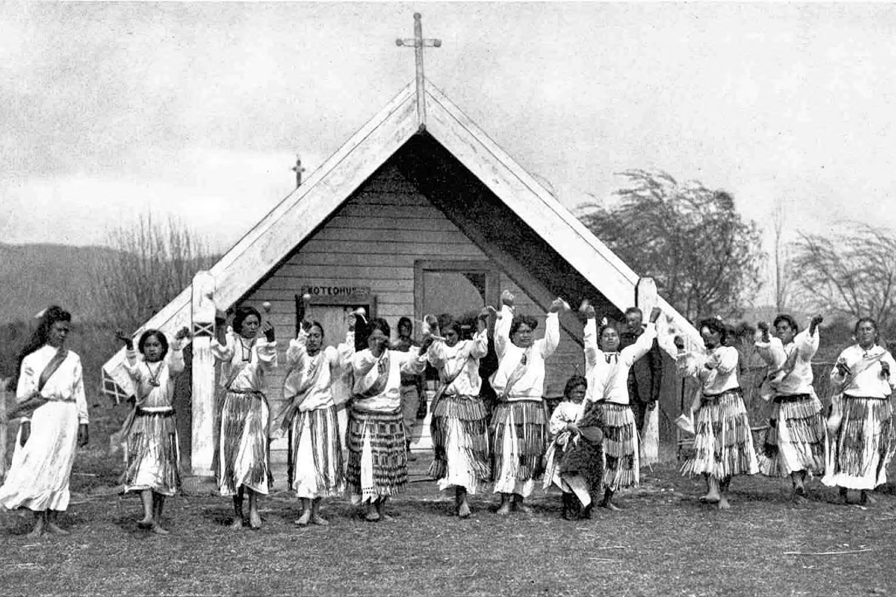 A historic photo of Maori people outside of a Marae.