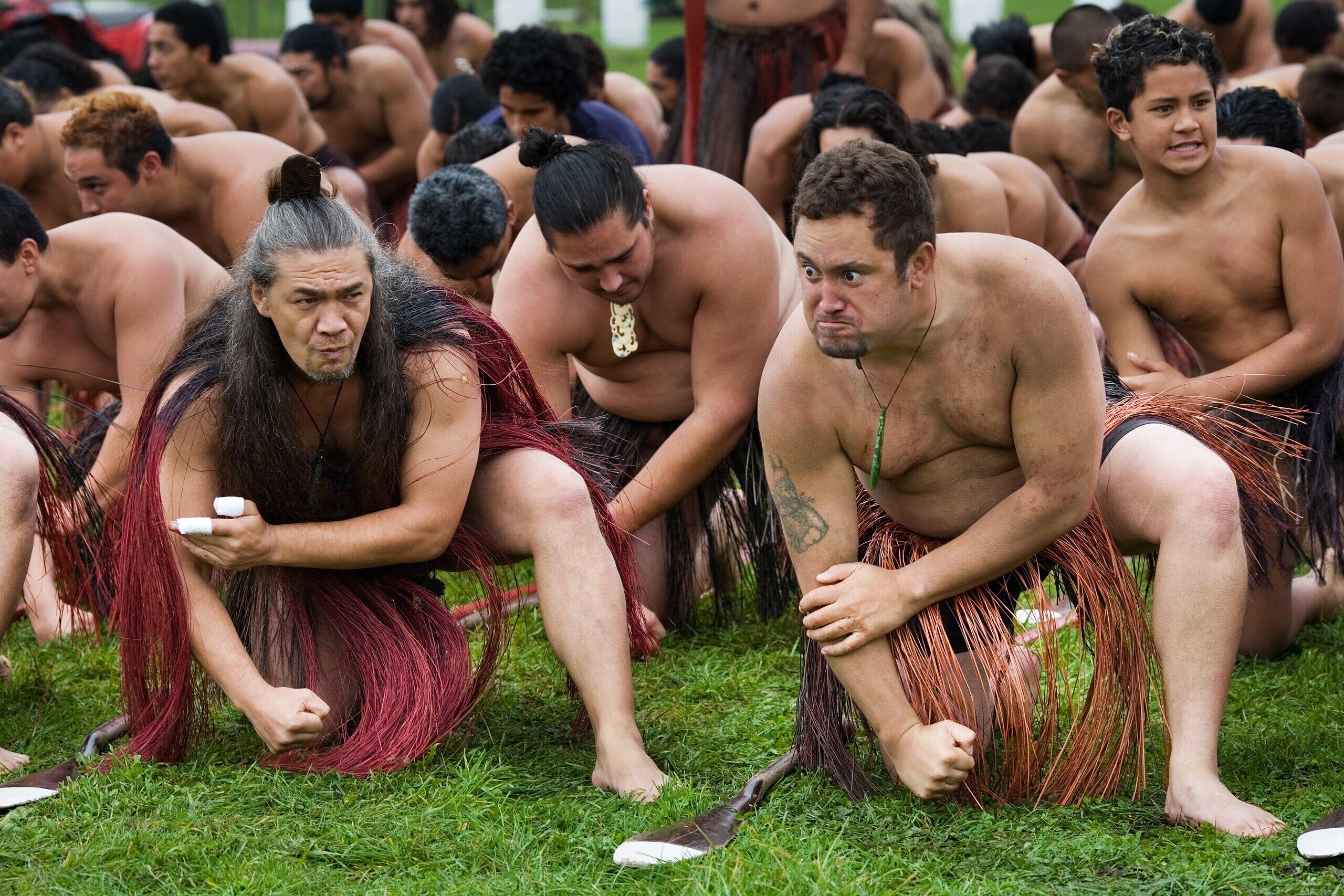 Maori performing together at a rowing ceremony.