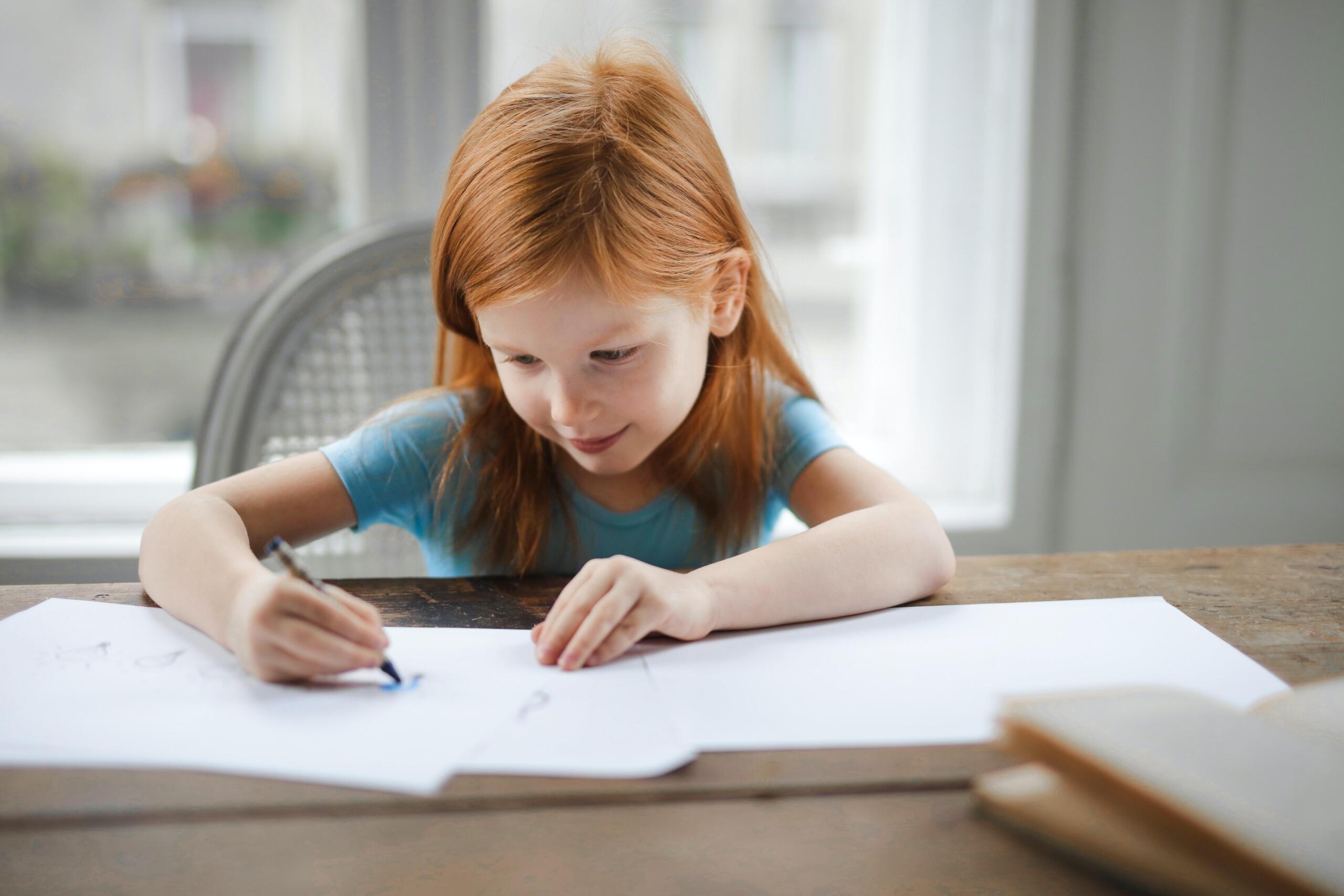 young girl studying and writing in a book