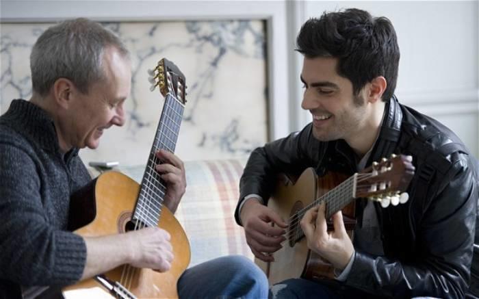 A guitar teacher teaches his student