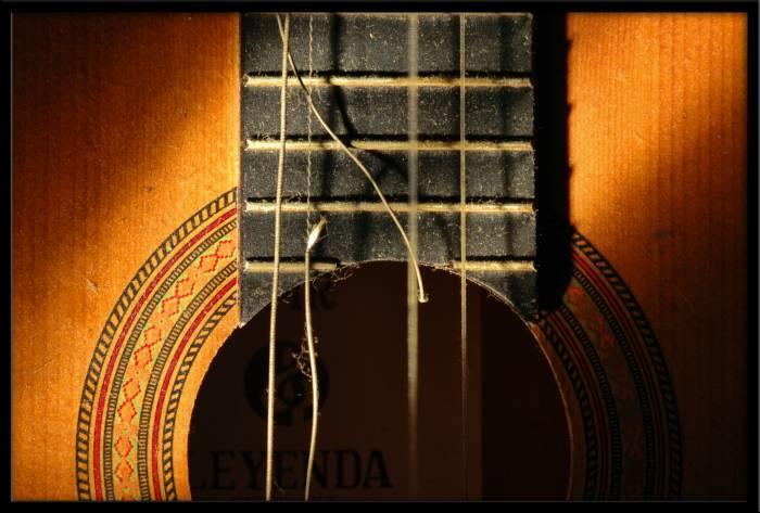 A dusty guitar with broken strings