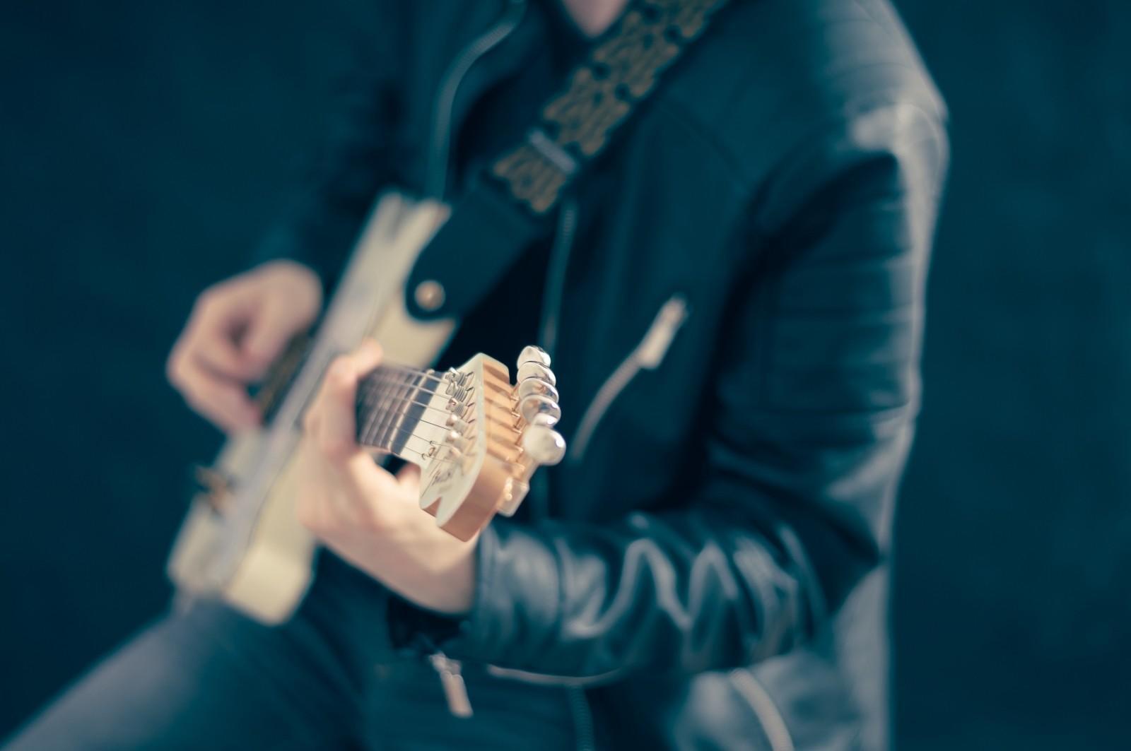 a man playing guitar with strap