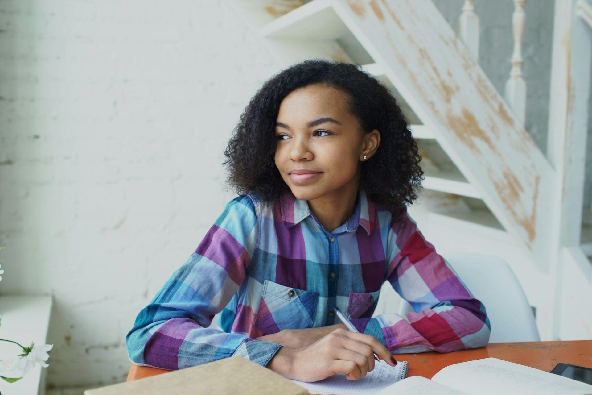 Student studying at a desk with an open notebook