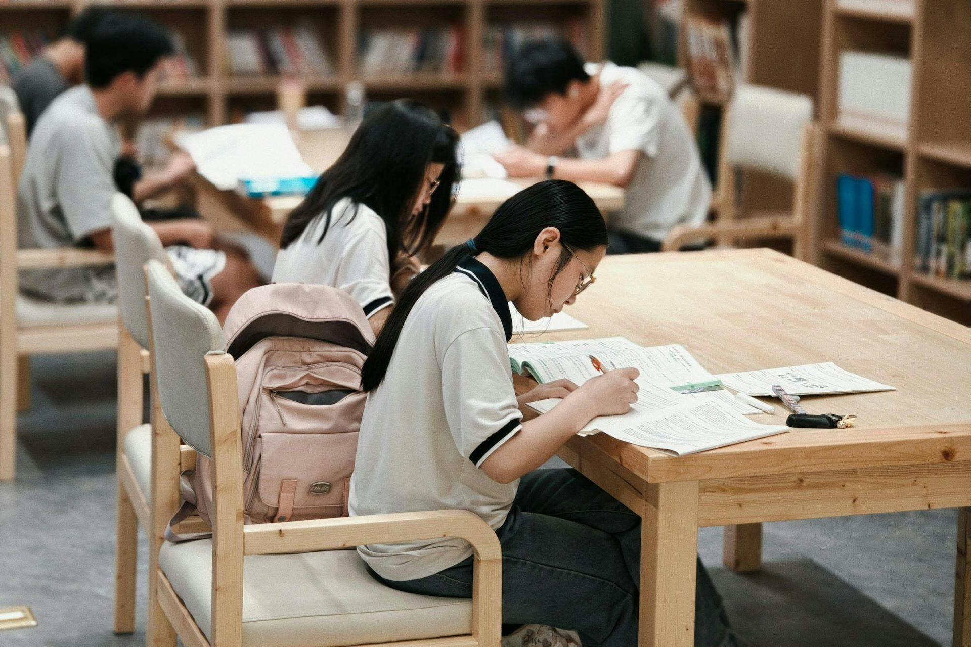 Students studying at tables in a library