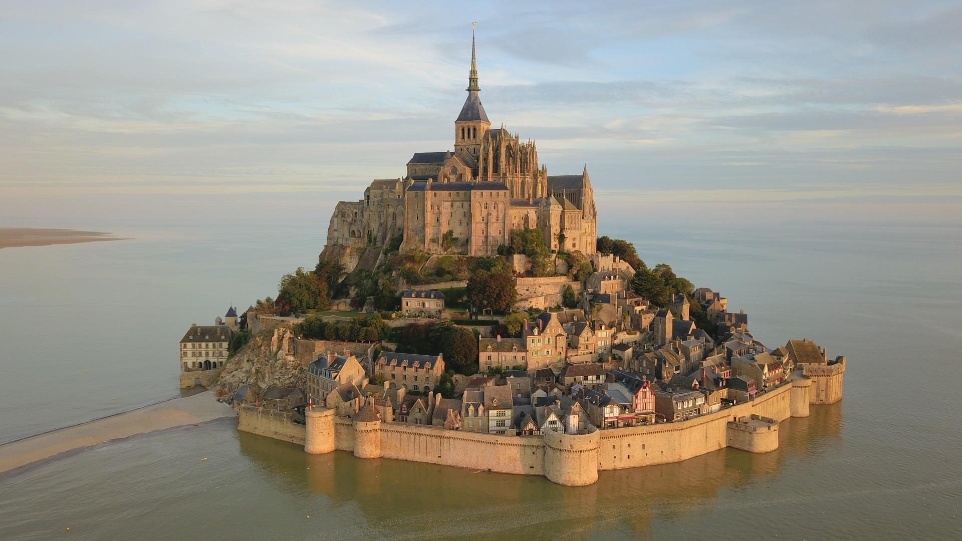 A fortress built upon a small island, surrounded with water. 
