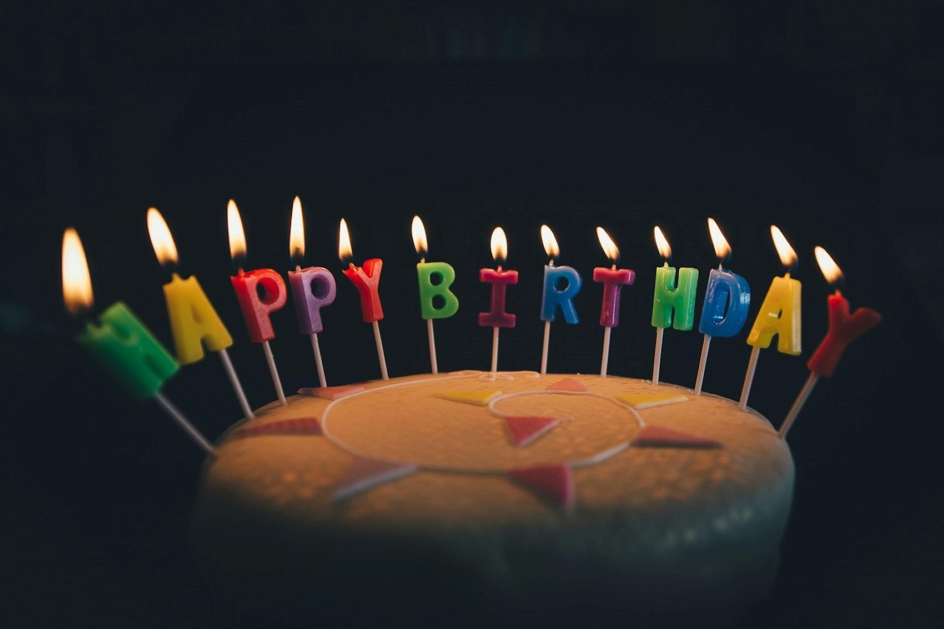 A cake with candles that spell happy birthday.
