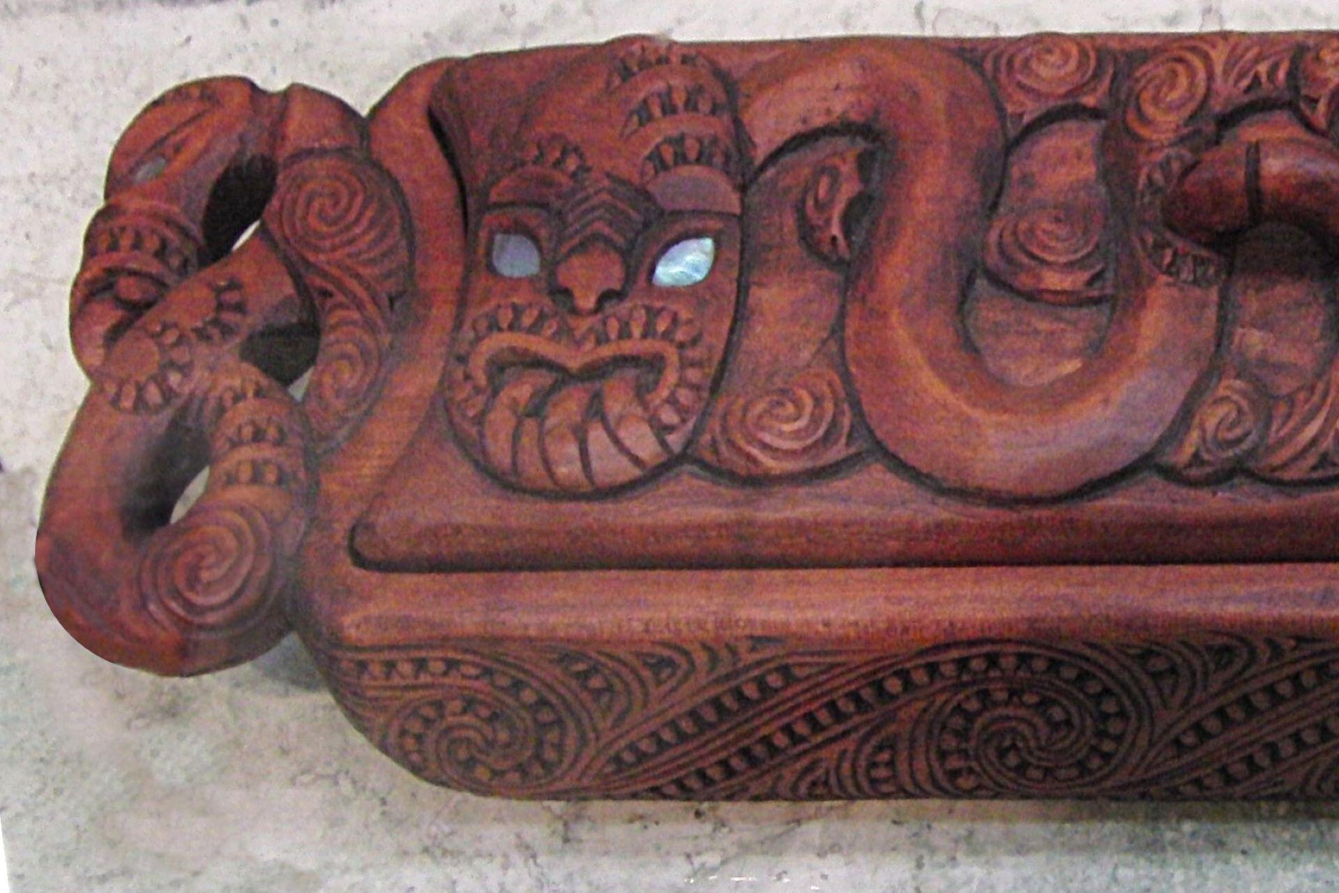 Carved wooden pencil box featuring Māori motifs symbolising Ranginui and Papatūānuku.