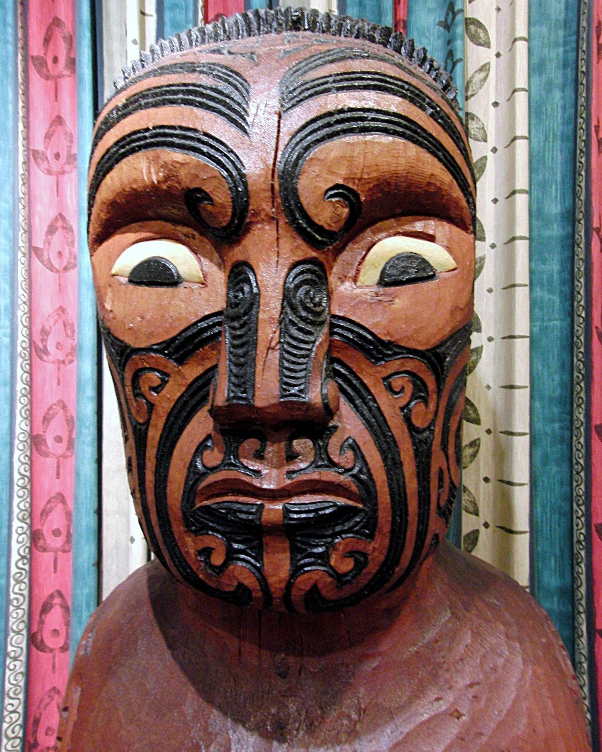 Carved Māori figure with intricate facial patterns representing Ranginui