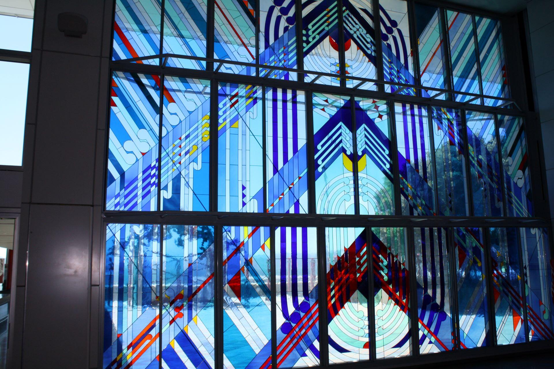 Stained glass artwork featuring geometric Māori designs inspired by Ranginui and the sky.