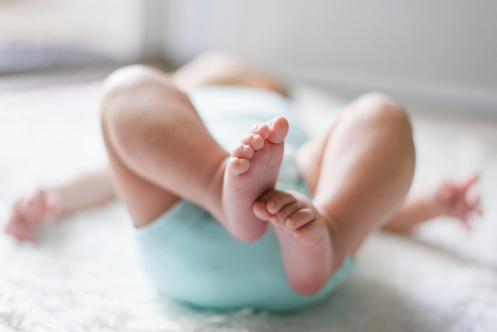 Baby feet close up while lying on bed