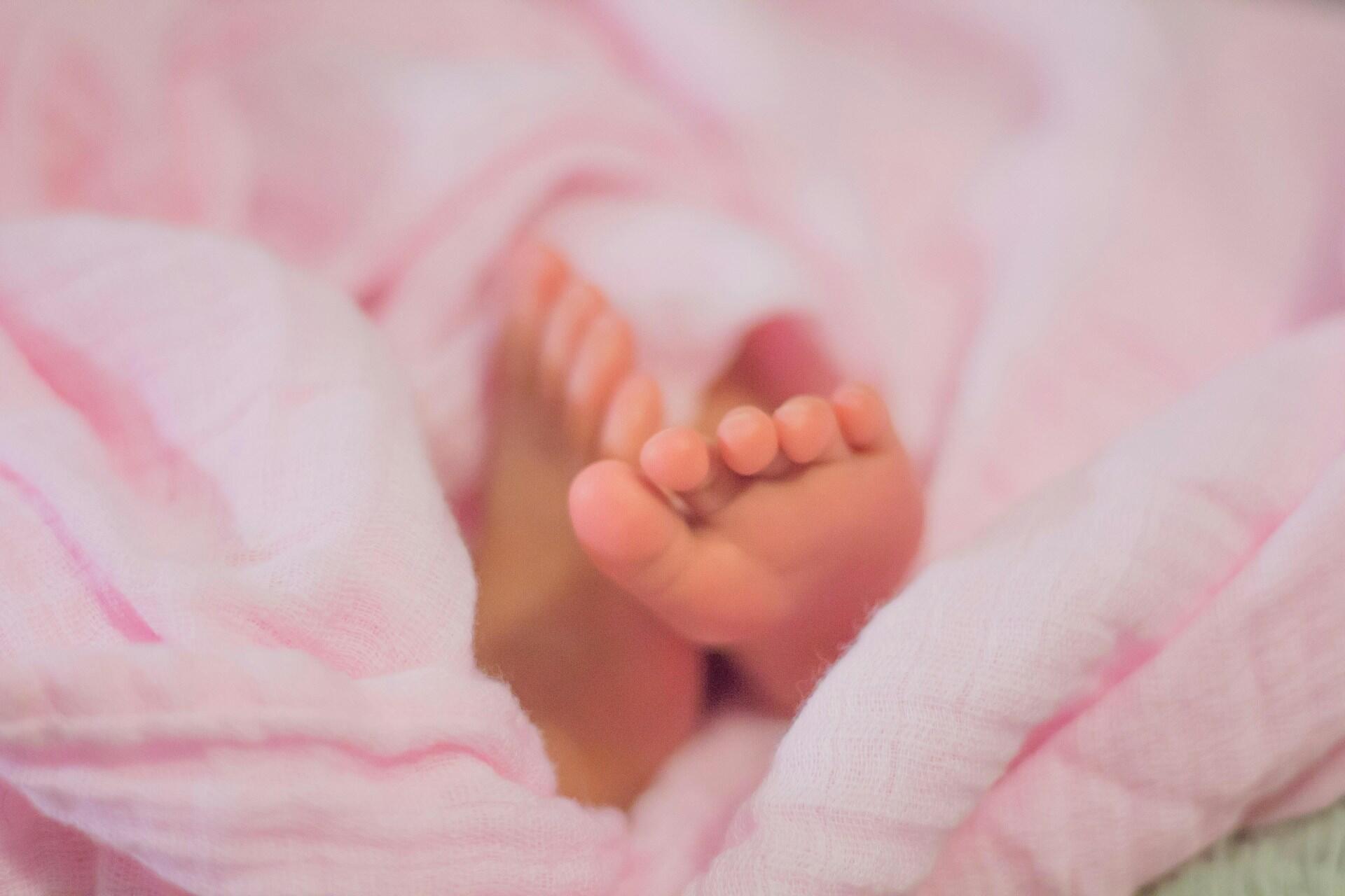 Baby feet wrapped in pink blanket